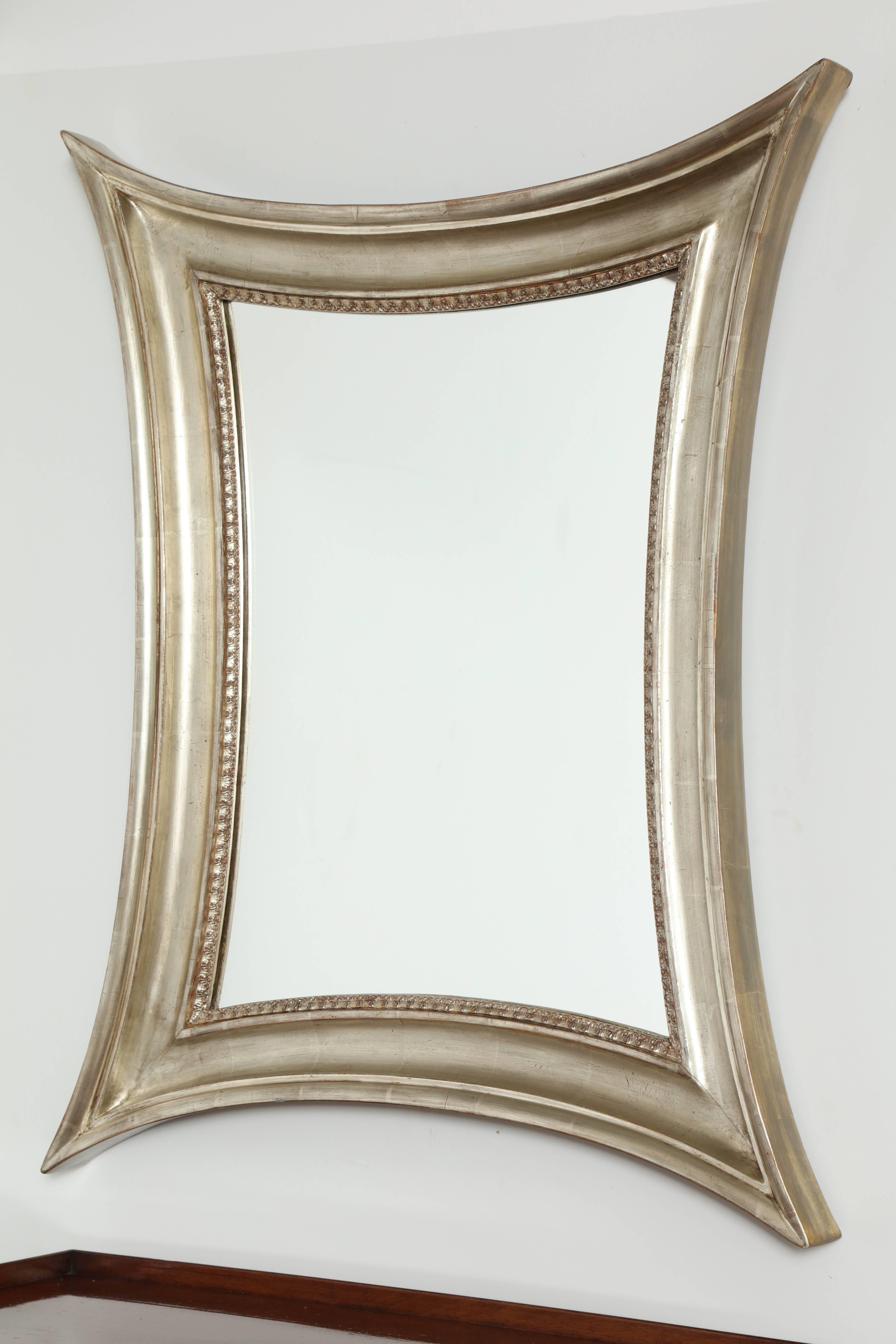 Un miroir danois en bois doré argenté, vers les années 1860, avec des côtés concaves et un cadre à section en creux profond et un bord intérieur moulé et feuillagé. Miroir remplacé mais pas neuf.