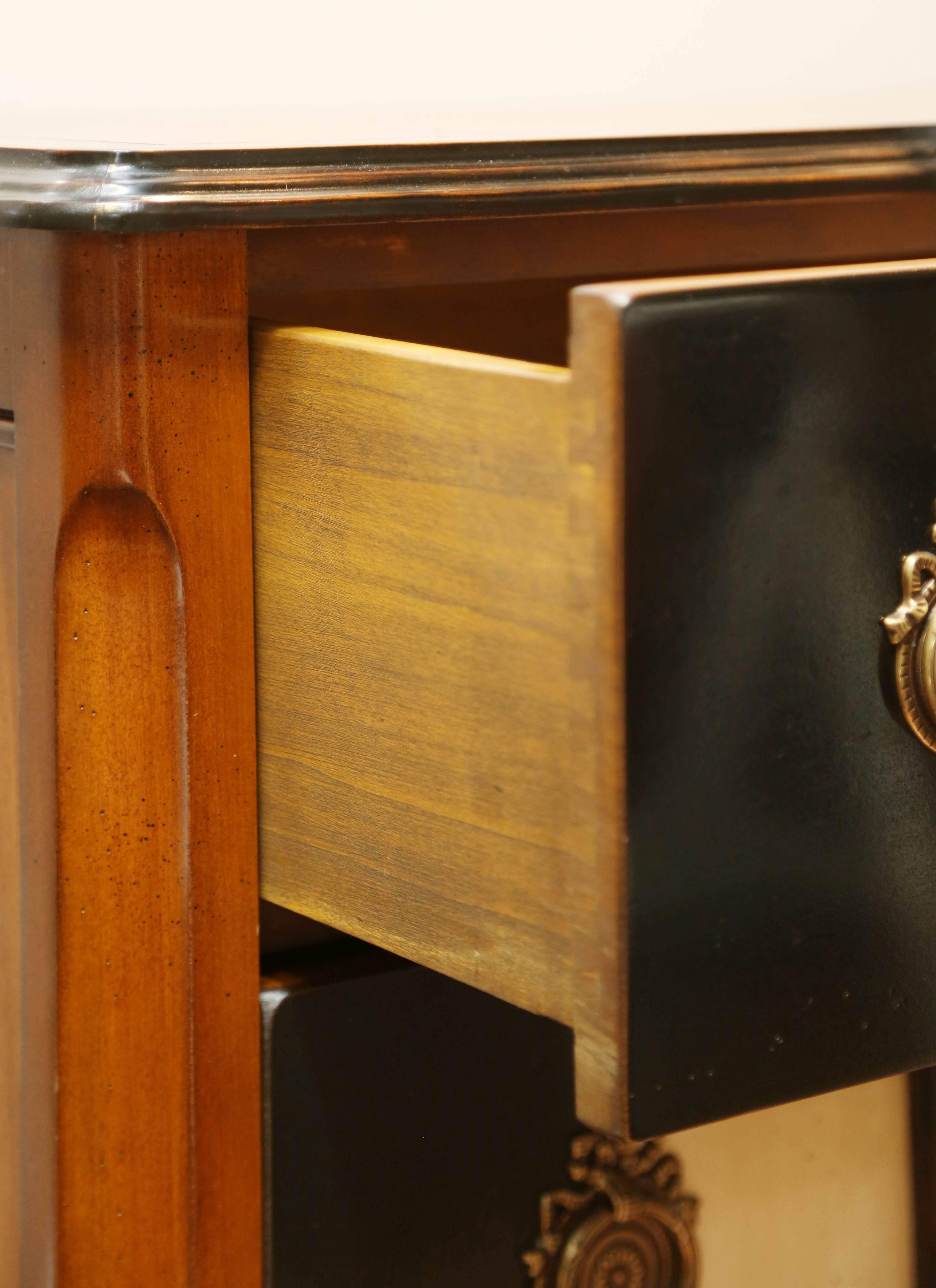 Magnifique commode à deux tiroirs de style Louis XV. Les deux tiroirs sont rehaussés d'une bande blanche et noire antique.