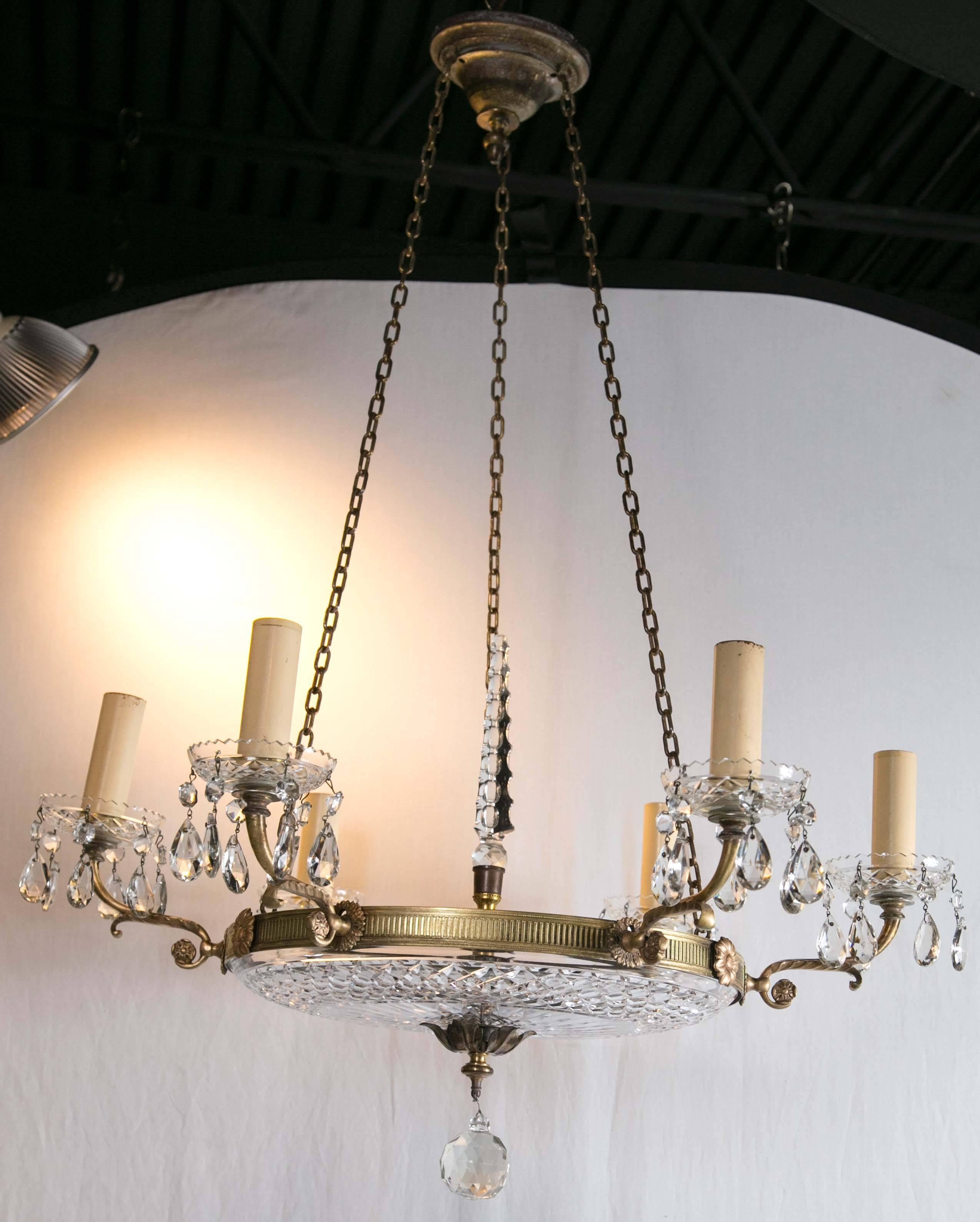 A circa 1930 French gilt bronze chandelier with cut crystal inset.