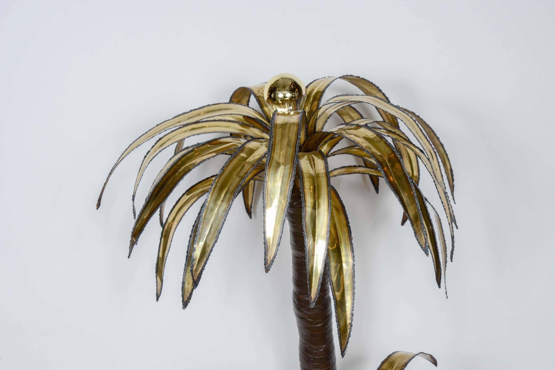 Classic piece from Maison Jansen, the palm tree floor lamp.

Wood foot with a brass sheet on top, three plants with shinny brass leaves.