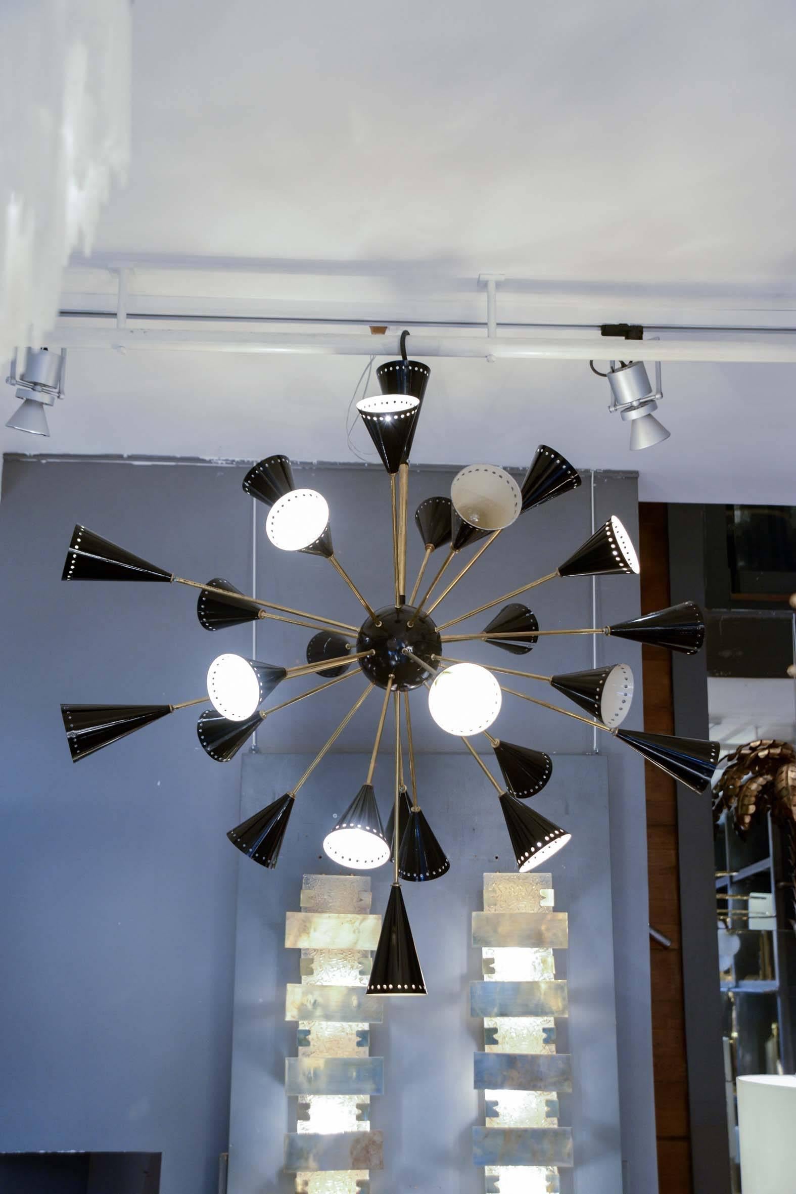 Big Sputnik style chandelier made of brass arms and painted in black central ball and sconces. 25 arms of light.