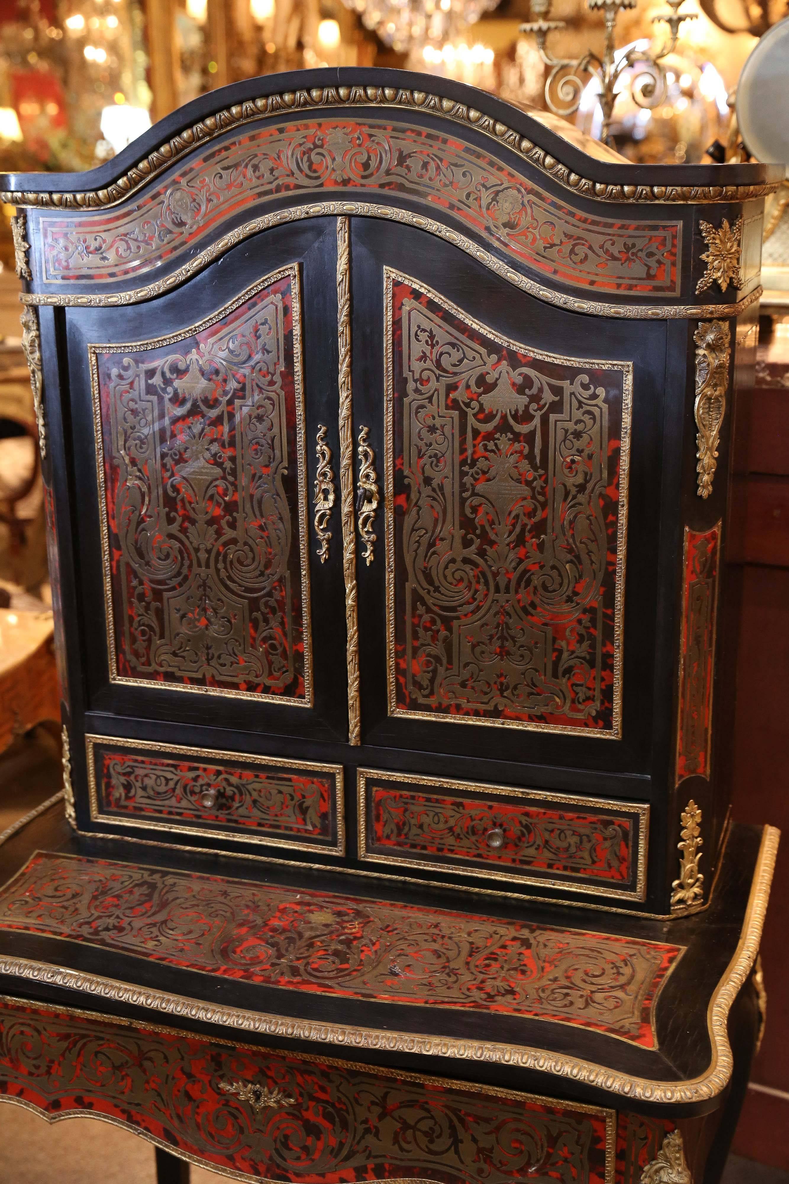 Boulle desk in rich color with bronze inlay. The upper structure is a bookcase
having doors that lock. Two drawers under the bookcase with one larger
drawer in the desk.
 