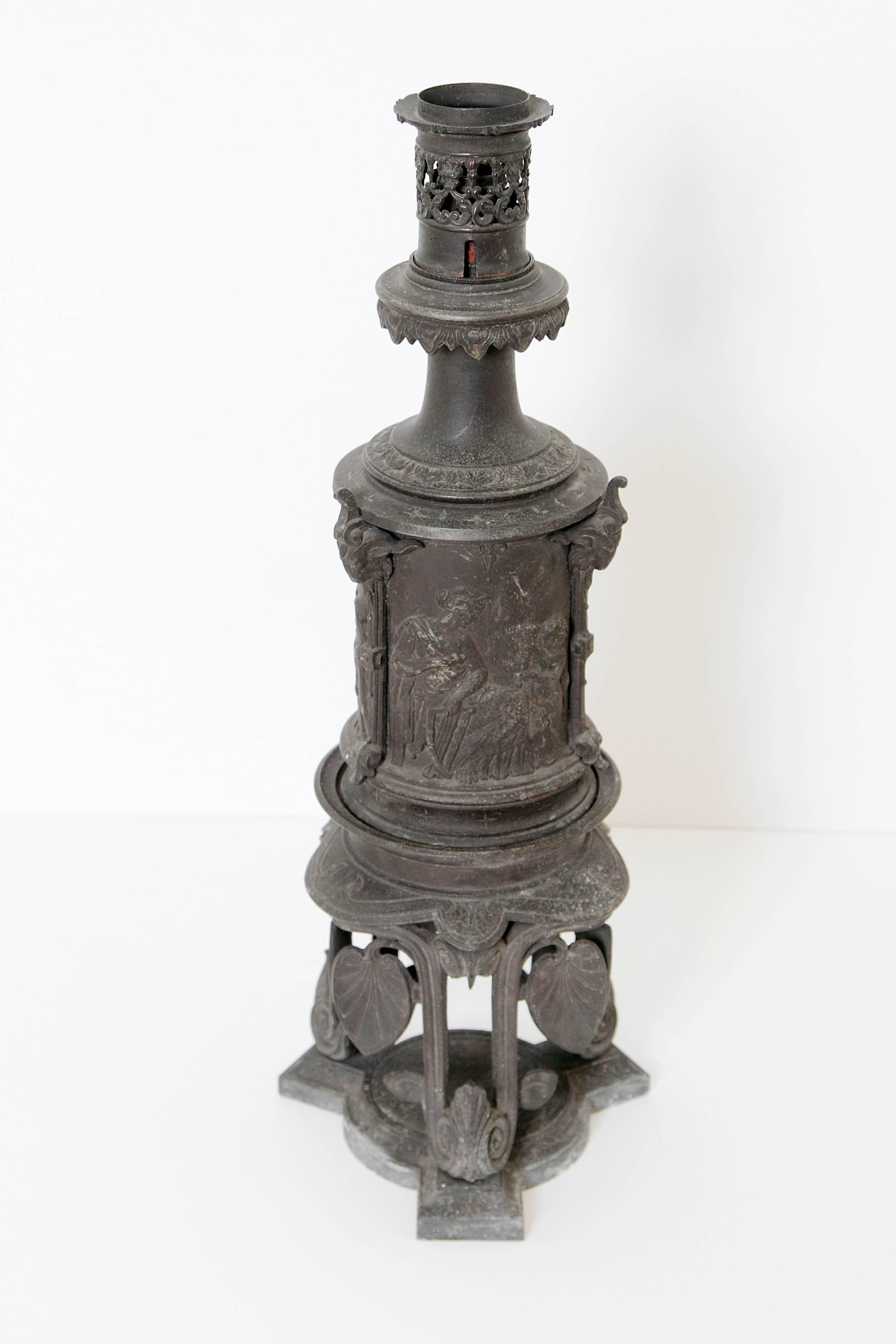 Interesting Napoleon III cast-spelter (looks like cast iron) carcel lamp on stand from the third quarter of the 19th century. Neo-Grec stylized decoration. 

Burner has been replaced by an electrical socket, however it is not in working order.