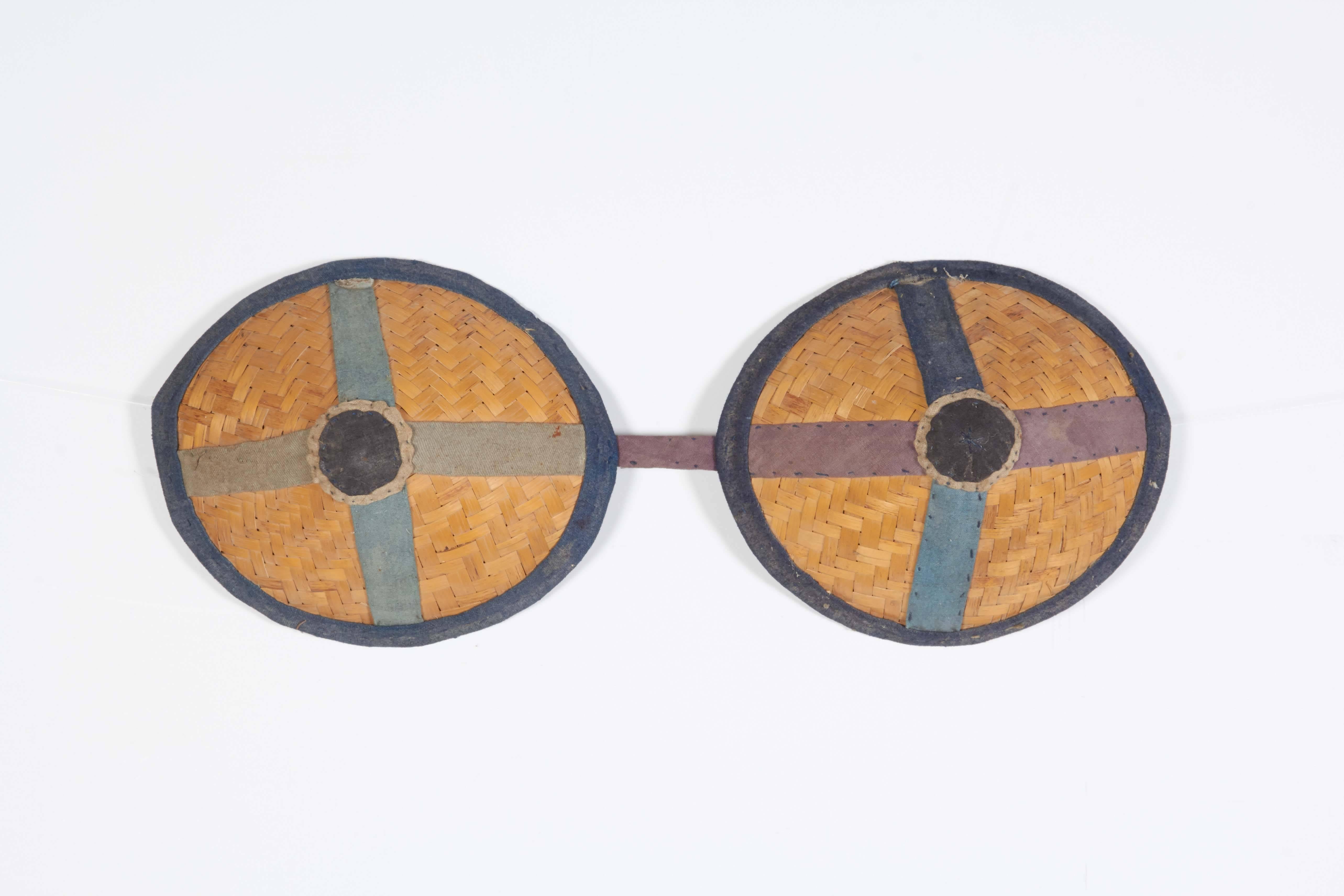 A striking pair of antique Chinese donkey blinders. Often confused with an item of women's apparel, these are in fact beautifully handwoven and hand-stitched pieces used to cover a donkey's eyes to prevent dizziness while walking in circles. Rarely
