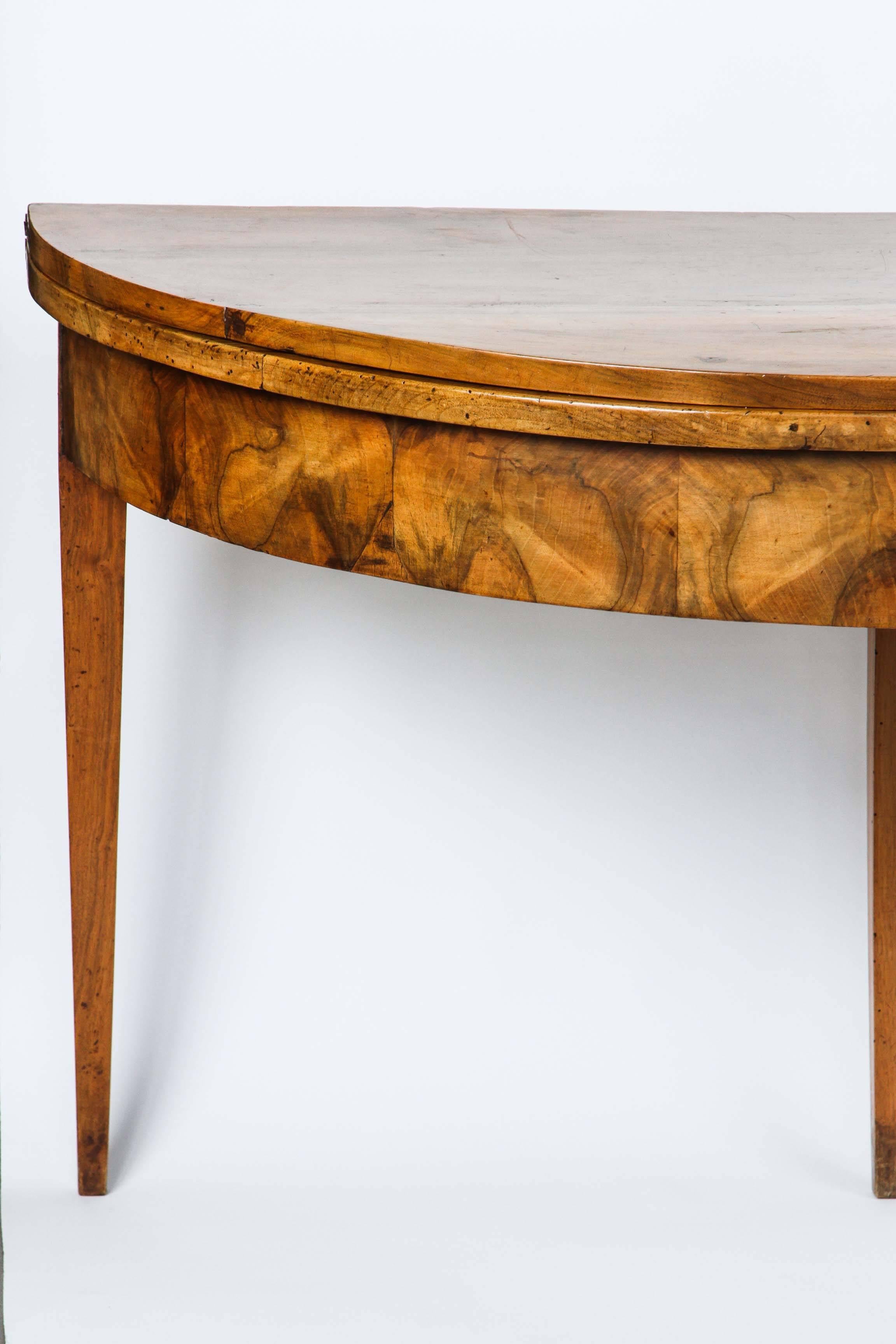 A large-scale French walnut demilune fold-over table with back centre pull-out leg (includes a drawer). It has the original, beautiful patina, circa 1820-1840.