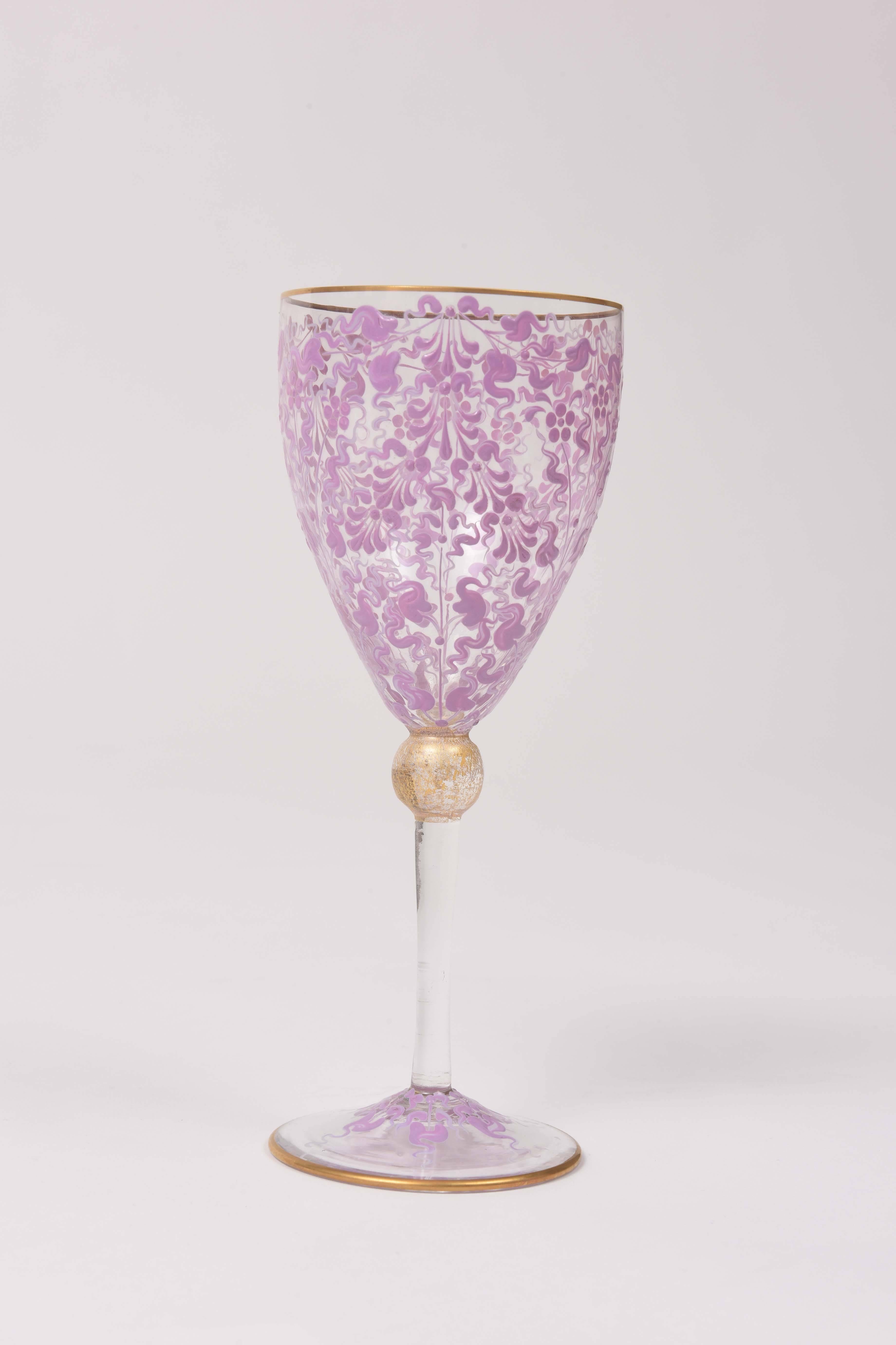 An exquisite set of 12 Venetian wine glasses that has been beautifully blown and features a double color pink hand enamel pattern on its bowl and stem. A nice gilded knob stem makes them a delight to hold and they have great balance. Trimmed on the