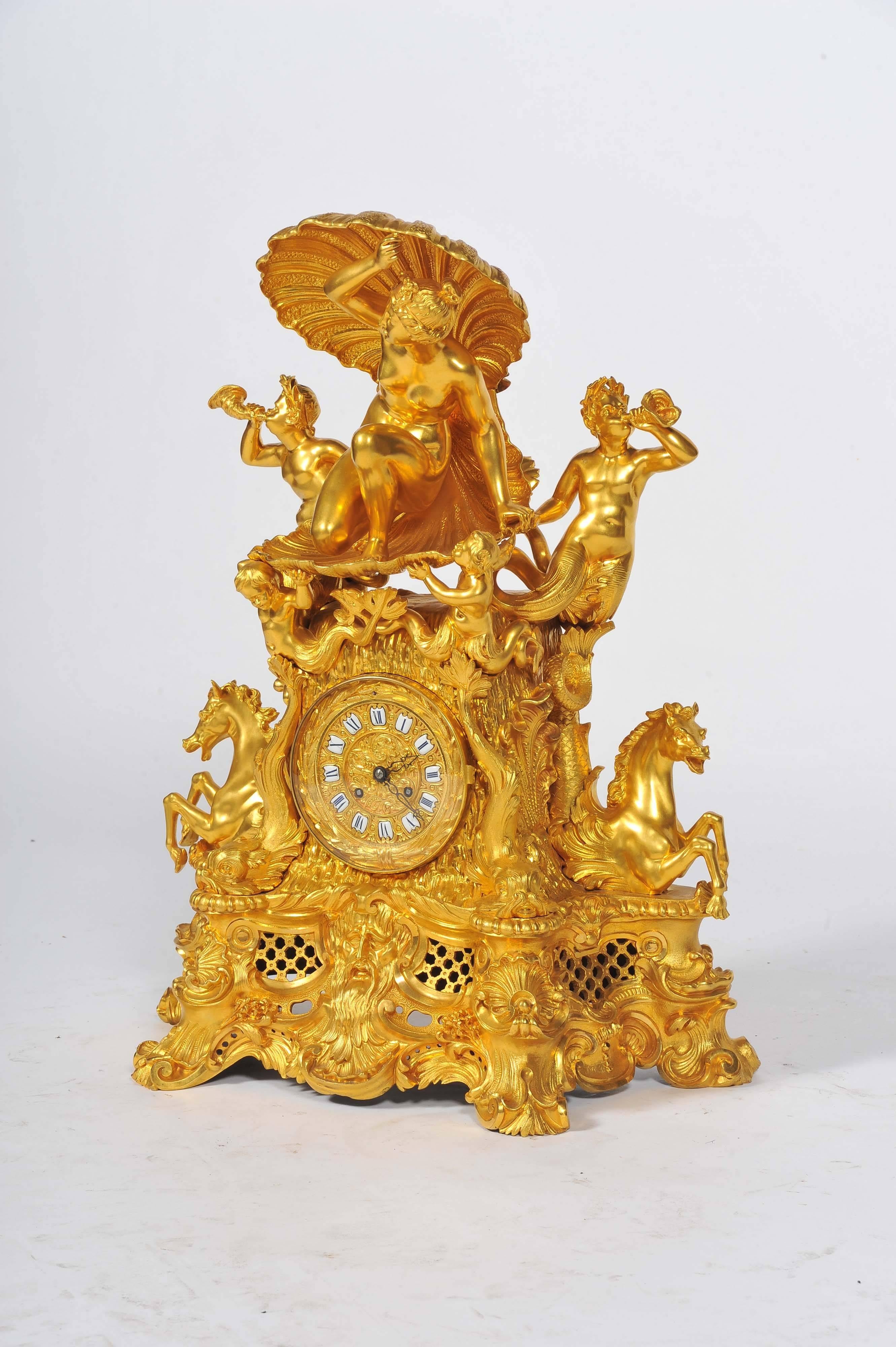 A very impressive gilded ormolu mantel clock, depicting sea shells, horses, urchins and dolphins. The eight day striking clock with enamel numerals.