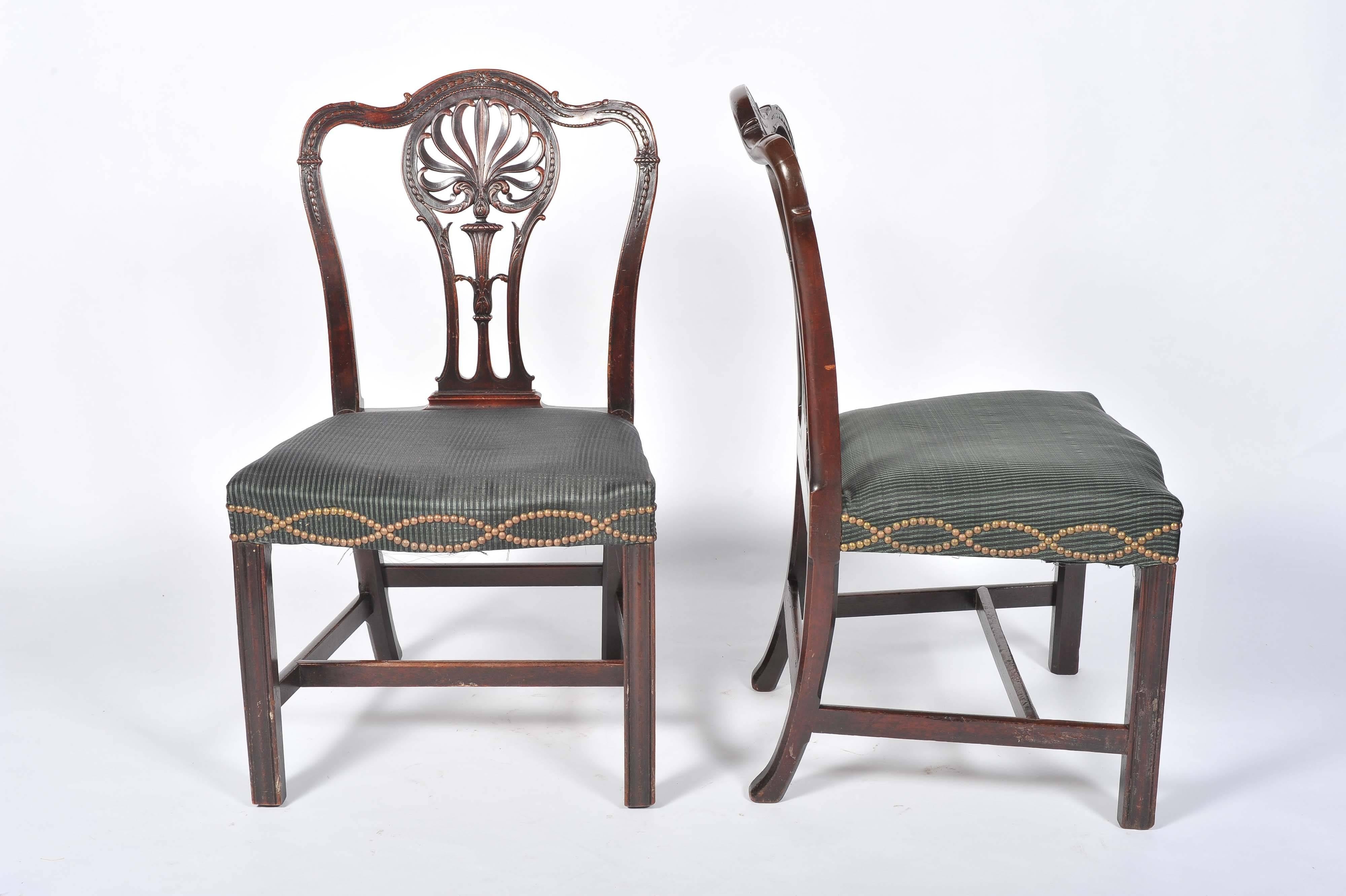 A good quality pair of Adam influenced side chairs having carved foliate decoration to the splats. serpentine shaped seat with close nail upholstery, raised on a square section moulded leg.