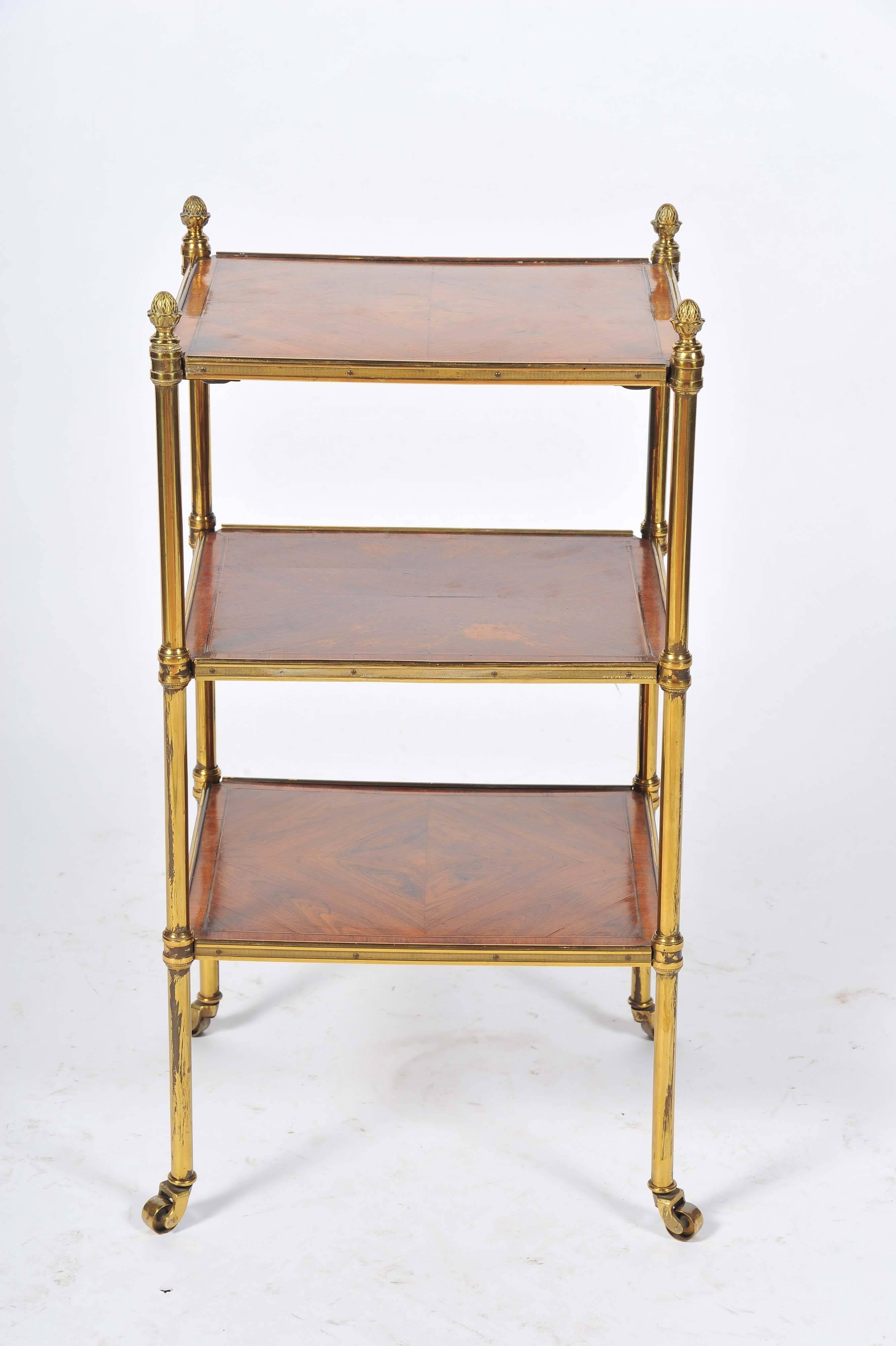 A good quality late 19th century rosewood crossbanded, brass three-tier etagere with pineapple finials.