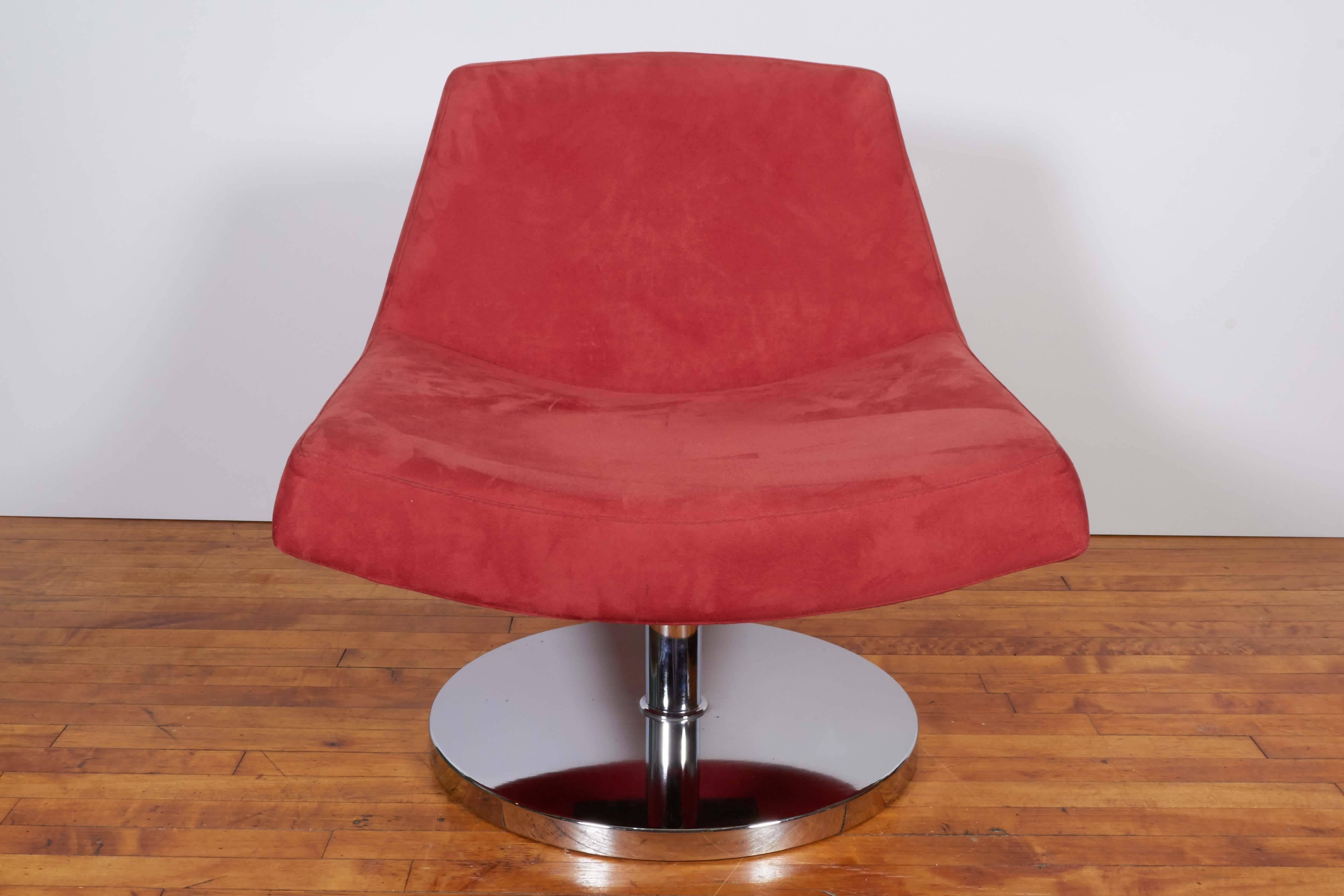 A pair of modern style slipper chairs, produced circa late 20th century, with cushioned seat and back entirely upholstered in red suede, raised on pedestal swivel circular base in polished chrome. Very good condition, with age appropriate wear to
