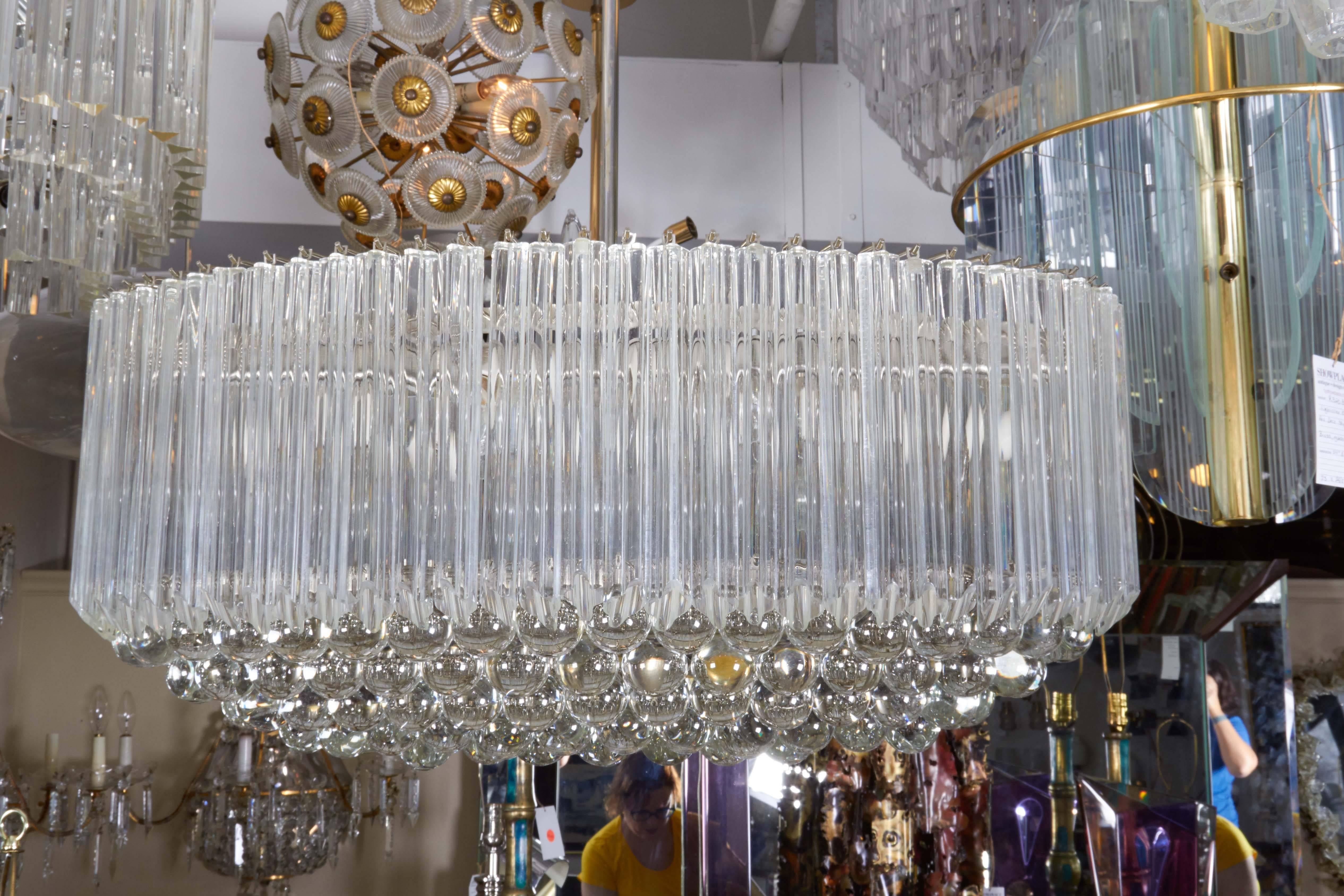 An Italian circa 1970s chandelier by Venini, with quatro punta Murano glass prisms and crystal balls suspended from a metal oval frame. Very good vintage condition, wear to metal and minor presence of chips to glass, consistent with age and
