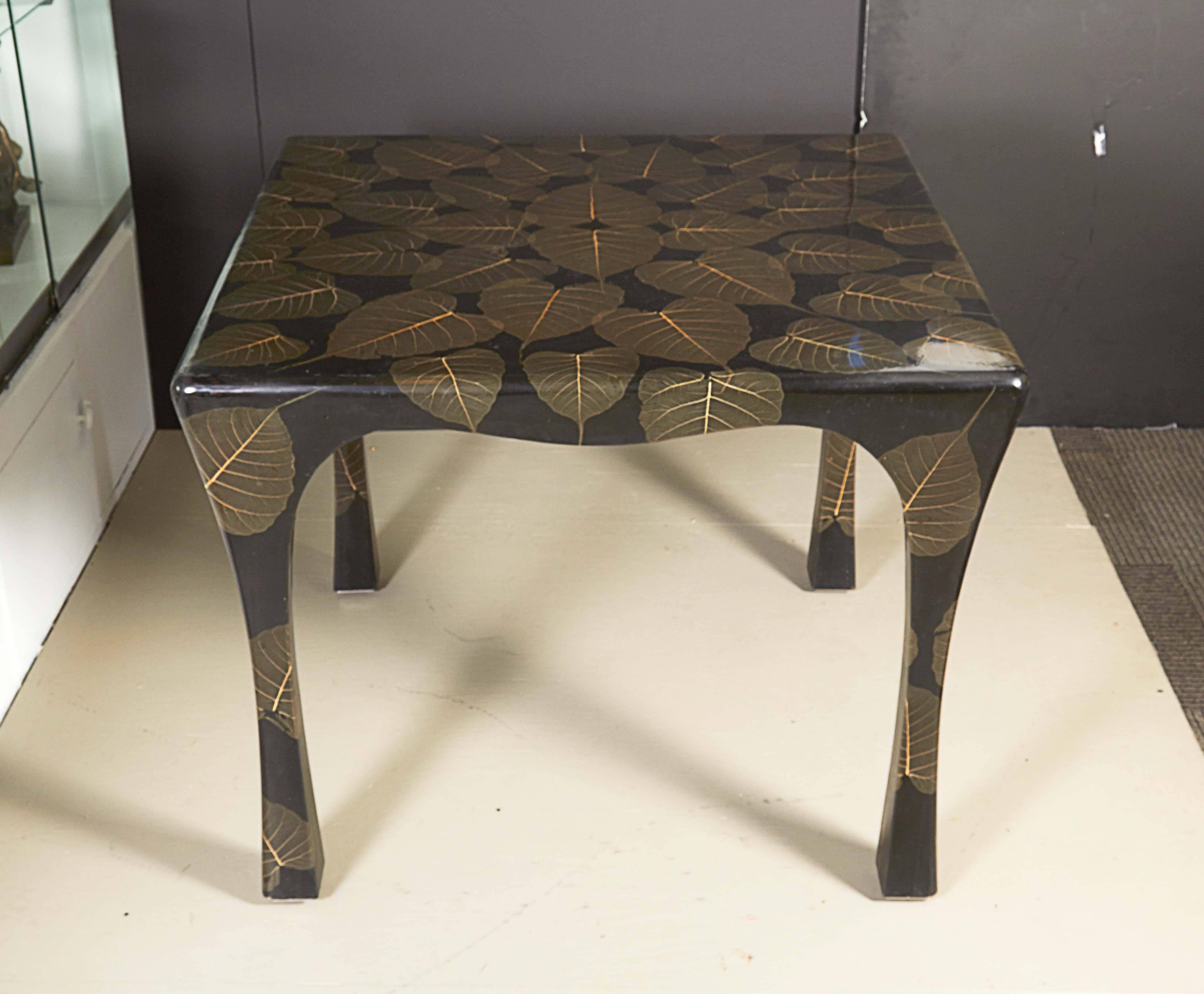 A vintage card table from the Mid-Century Modern era, the serpentine form inspired by Asian designs, entirely in black lacquered wood, surface layered with organic leaves and high gloss finish. Very good condition with age appropriate wear.

10858