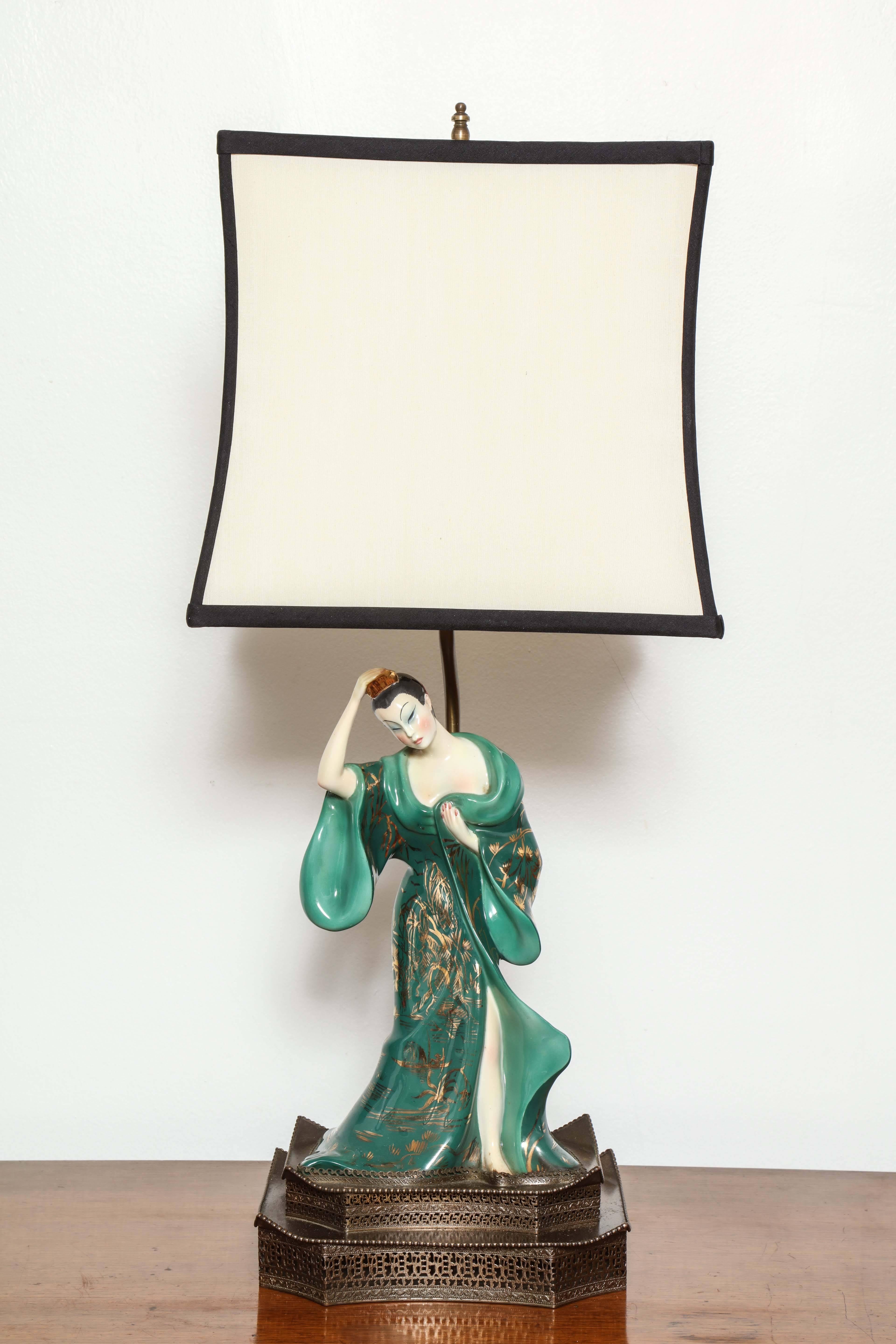 An unusual pair of Rosanna porcelain lamps mounted on antique bronze finish base. Beautiful hand-painted Italian figurines lend themselves to understated elegance. Sculptural in shape 17 inches tall base is 9 wide 6 3/4 deep shown with 10 x 10 x 10