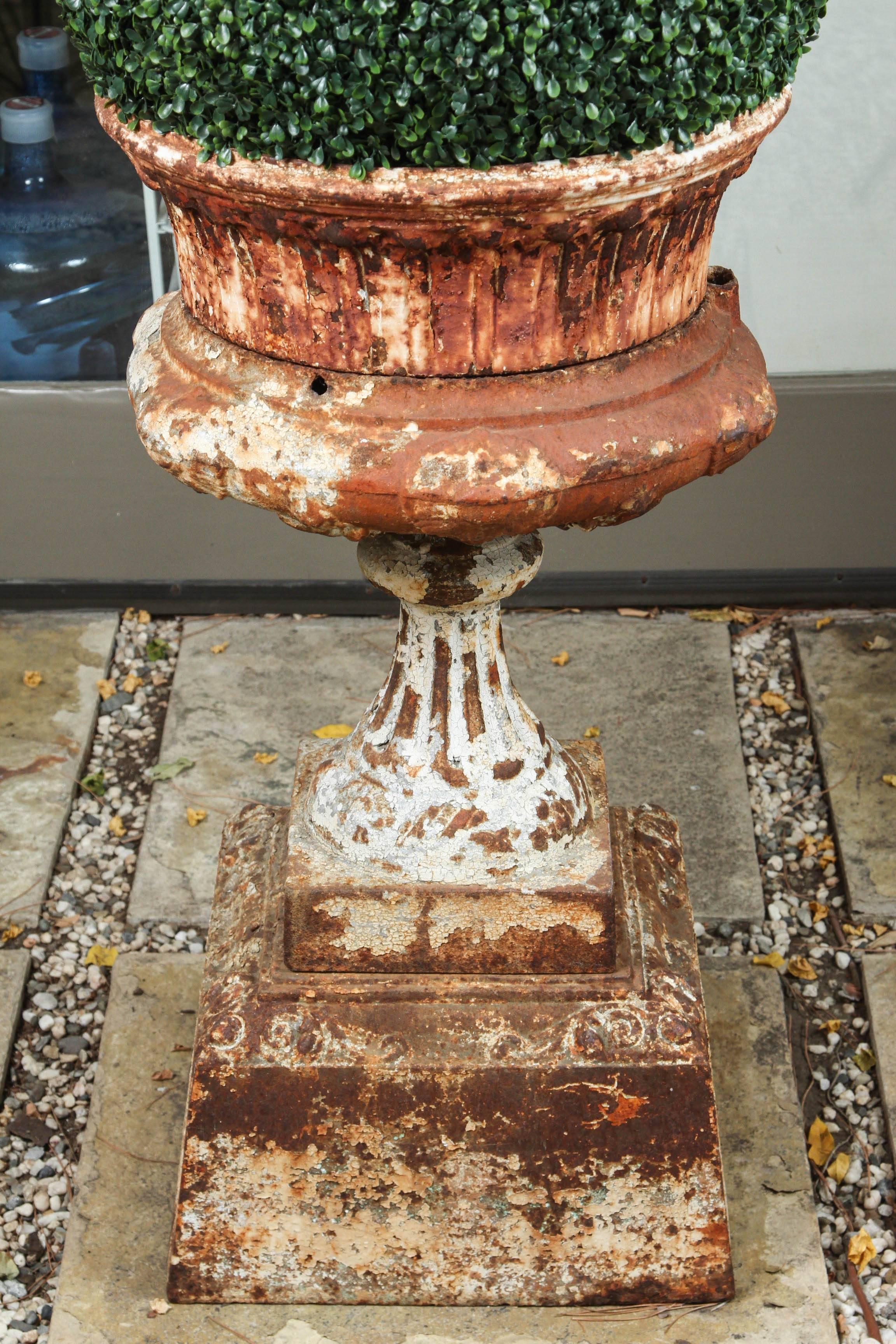 A large late 19th century American cast iron garden urn on a plinth base.
   