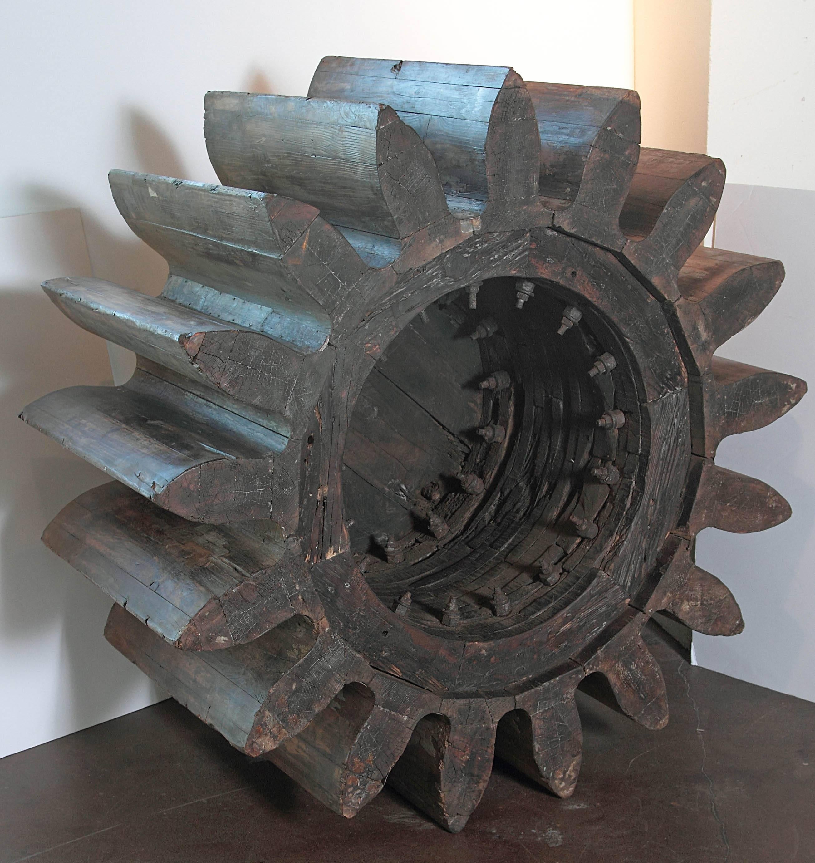 Large Industrial factory gear. 

Whether used as decorative art or as a base for a table, this factory gear is eye catching. Hand-carved solid pine, with Industrial metal ridges. From an 1930s English factory used to mold factory cast iron gears.