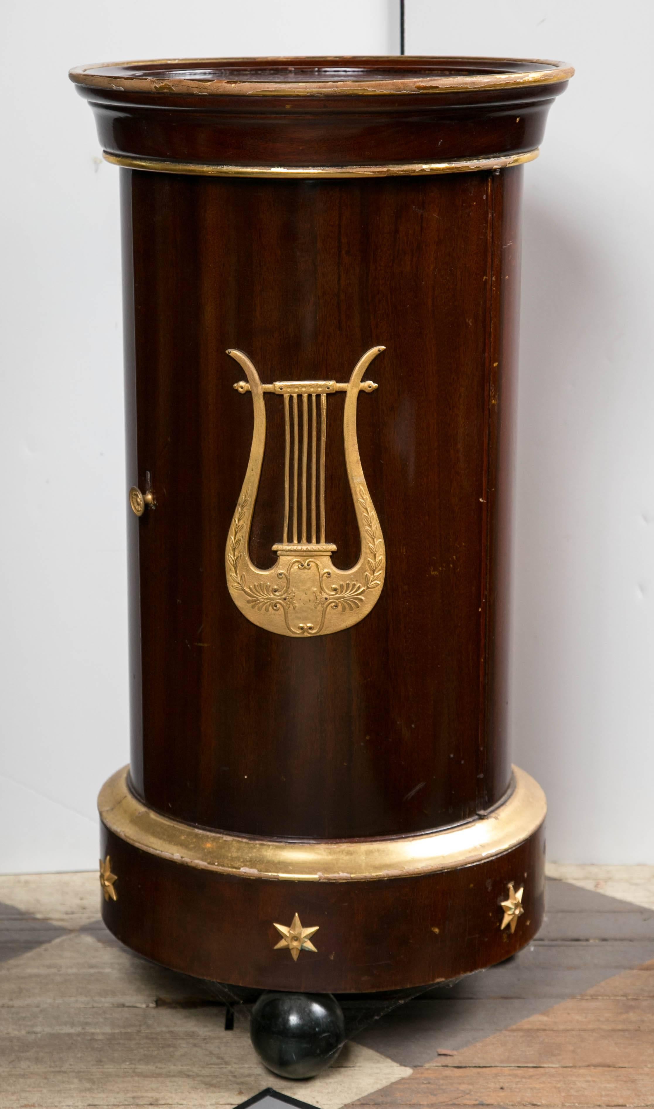 Sometimes referred to as a pot table, these were used to hold a chamber pot in the bedroom. This one, dating from the early 19th century is of the French Empire period. It is of mahogany solids and veneers.
Giltwood edge around the top and at the