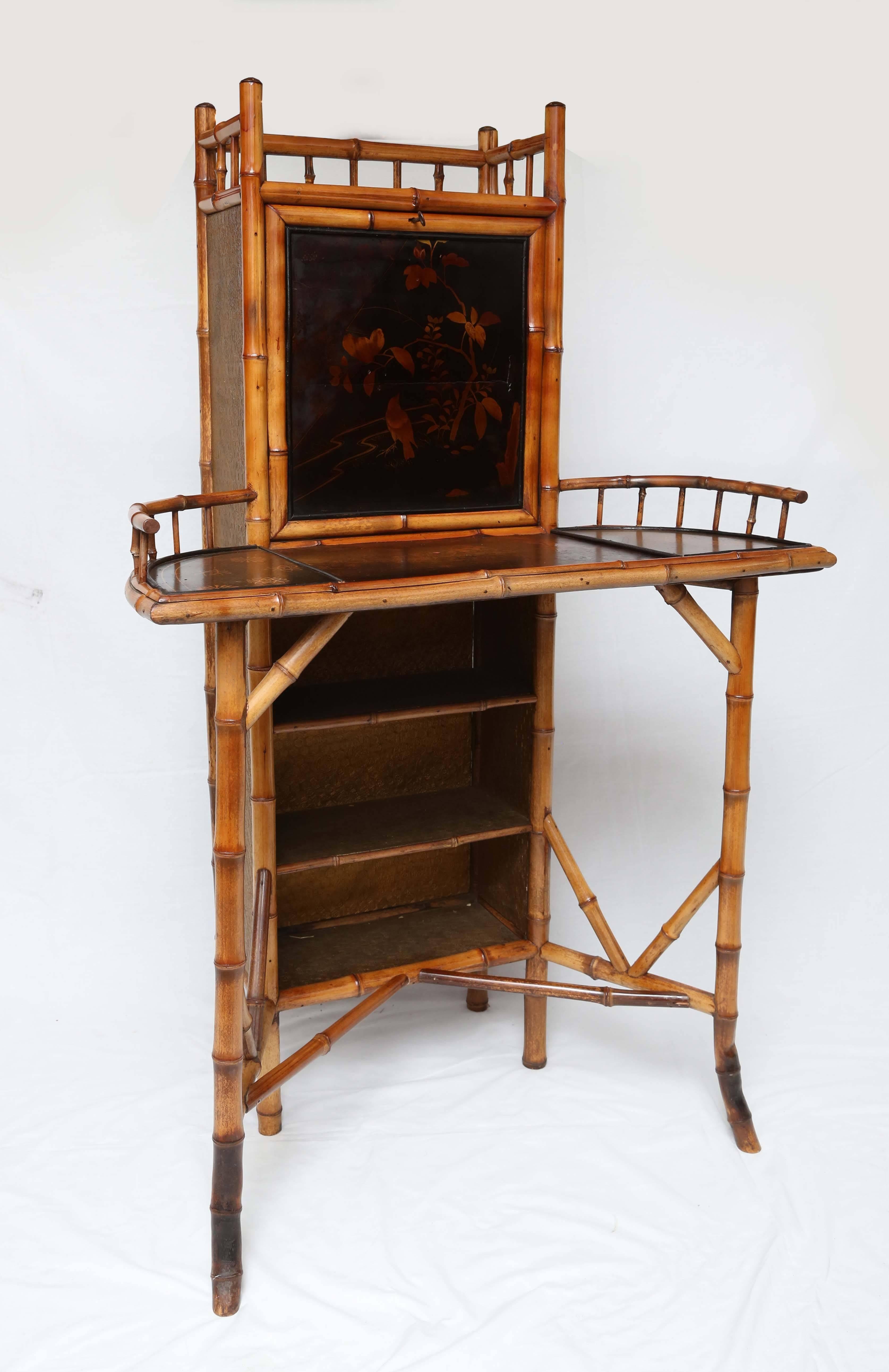 Bamboo drop front writing desk with fitted interior and oriental motif. Late 1800s natural finish. 50" tall.