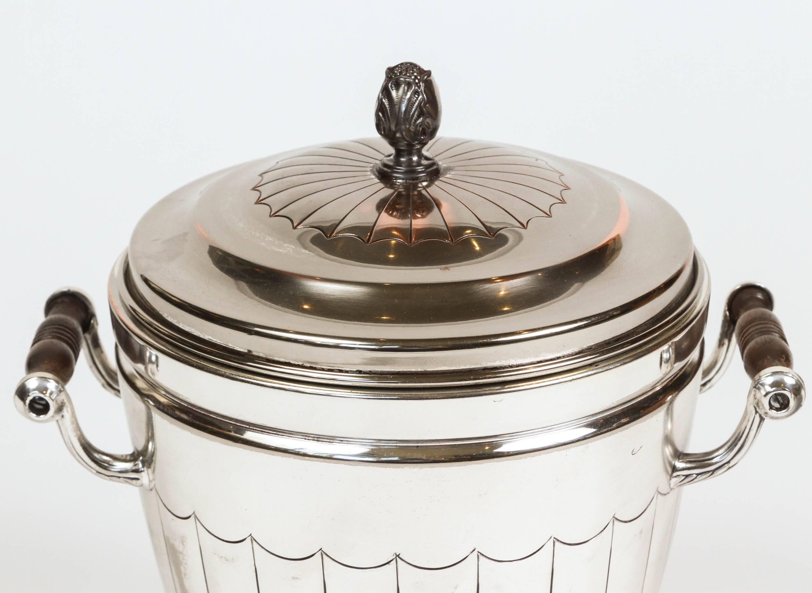 Vintage newly polished silver plate ice bucket with mercury glass interior and carved wood handles. It is stamped underneath 