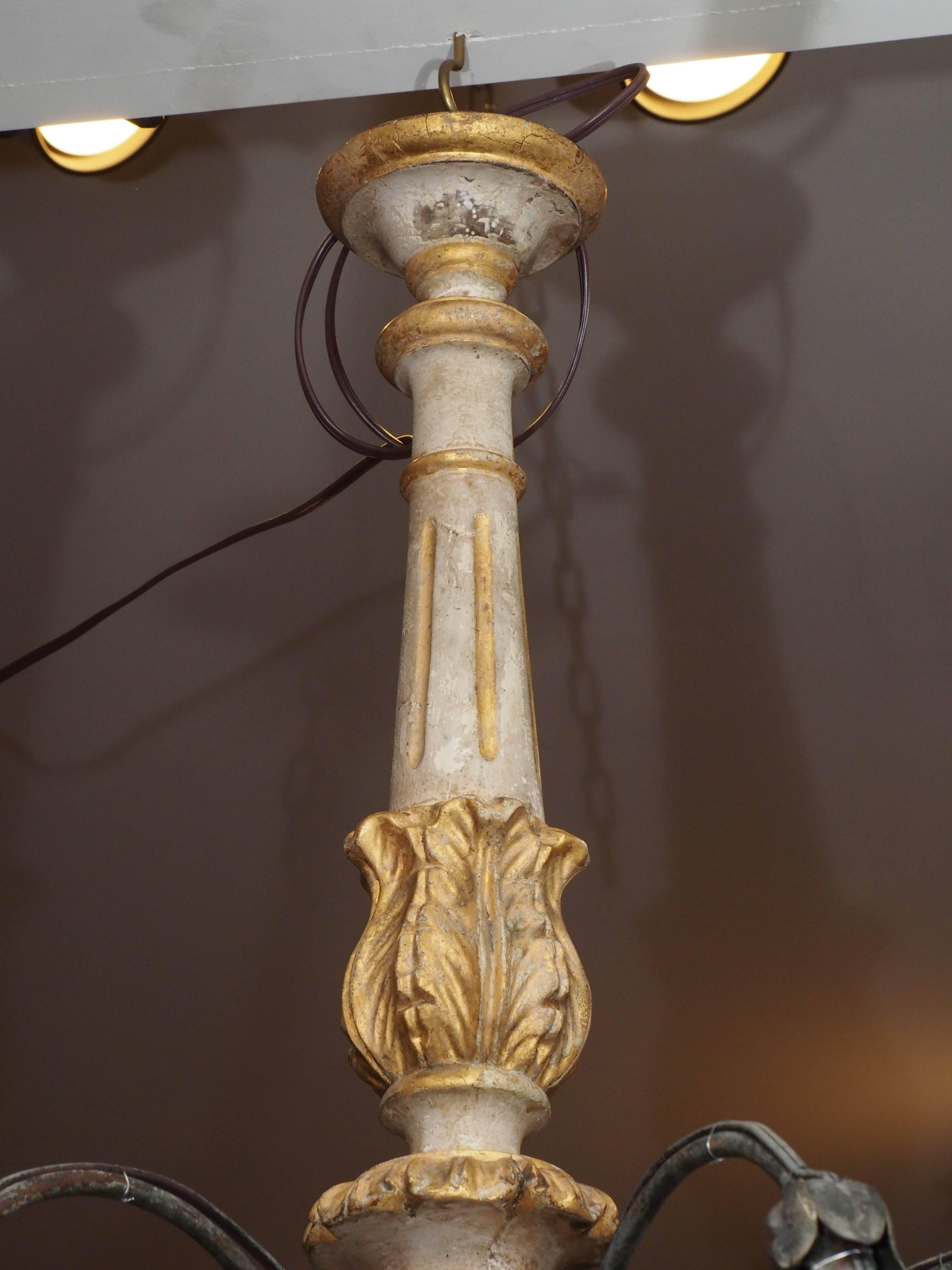 Italian painted and parcel-gilt wooden stemmed eight-light chandelier from Tuscany area. Iron arms. Has been re wired. No guarantee of this wiring after transport. Please have it checked. All chandeliers come with canopy and chain and real beeswax