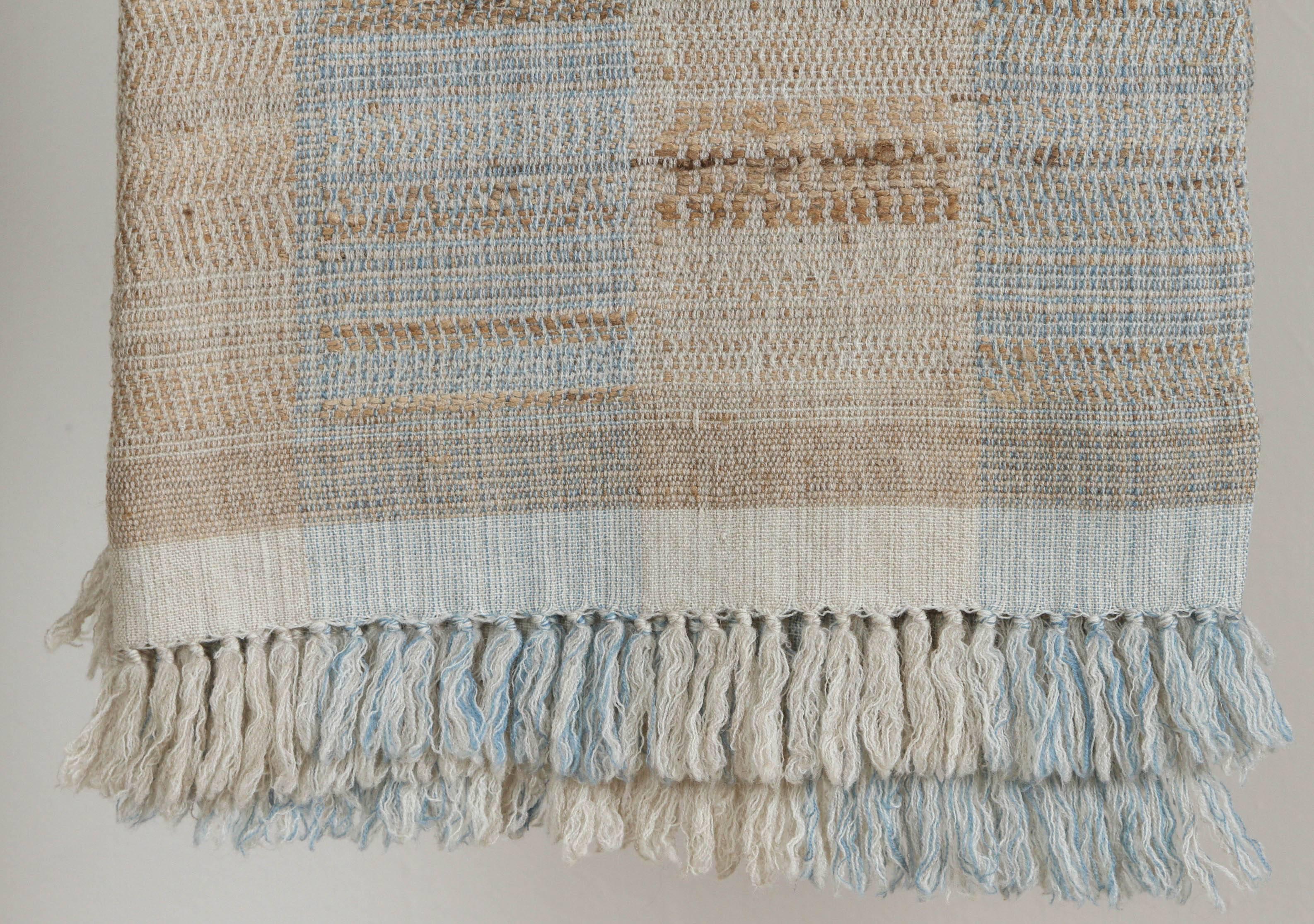 A contemporary line of cushions, pillows, throws, bedcovers, bedspreads and yardage hand woven in India on antique Jacquard looms. Handspun wool, cotton, linen, and raw silk give the textiles an appealing uneven quality.

The above throw is tussar