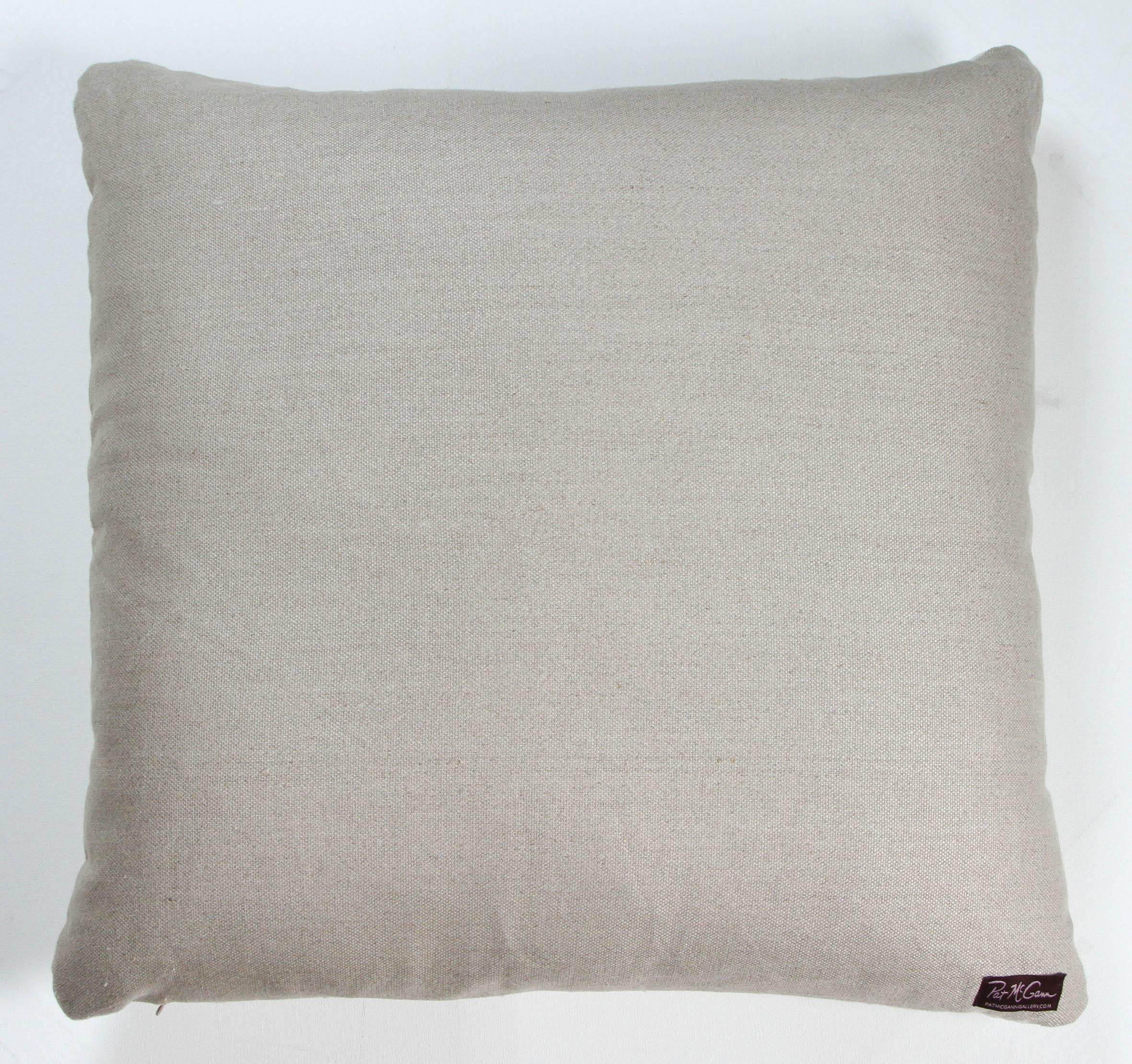 Cushion or pillow made from a Hausa Chief’s Robe, known as a Boubou. Hausa is the largest tribal group in Nigeria. Hand worked cotton floss embroidery over hand woven fabric made in narrow panels sewn together. Backed with natural linen, feather and
