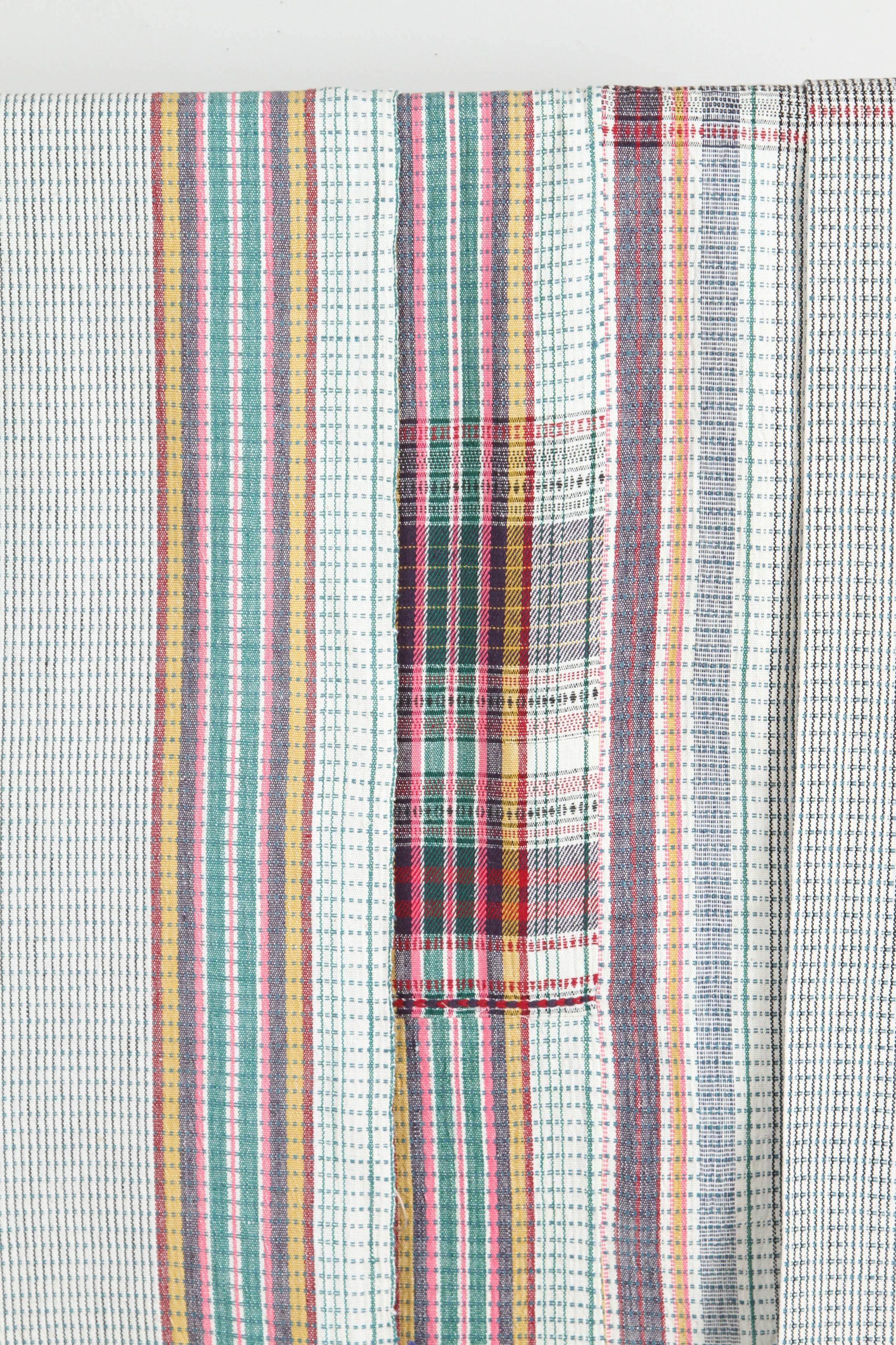 Kala naturally dyed organic cotton from Gujarat, India.  Hand loomed using traditional Indian textile techniques to produce extra weft woven stripes and plaids.  This yellow, blue, red, pink, black, green and ivory bedcover has added royal blue hand