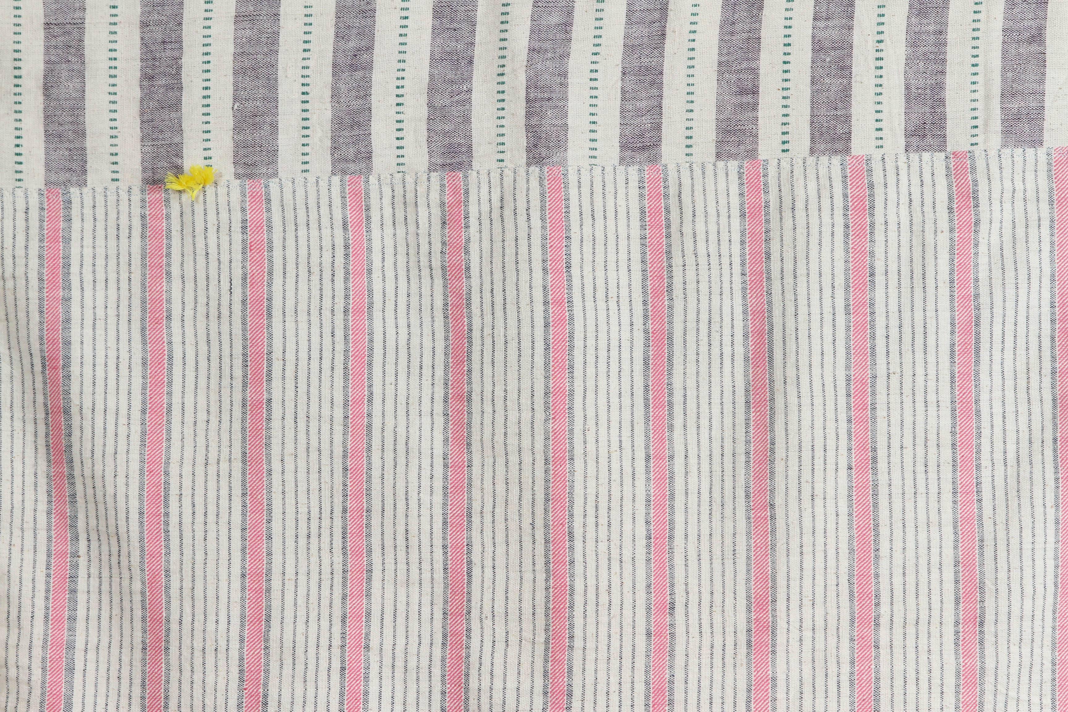 Kala naturally dyed organic cotton from Gujarat, India.  Hand loomed using traditional Indian textile techniques to produce extra weft woven stripes.  This ivory, lavender, green and pink bedcover has added pink, yellow and white hand knotted tassels