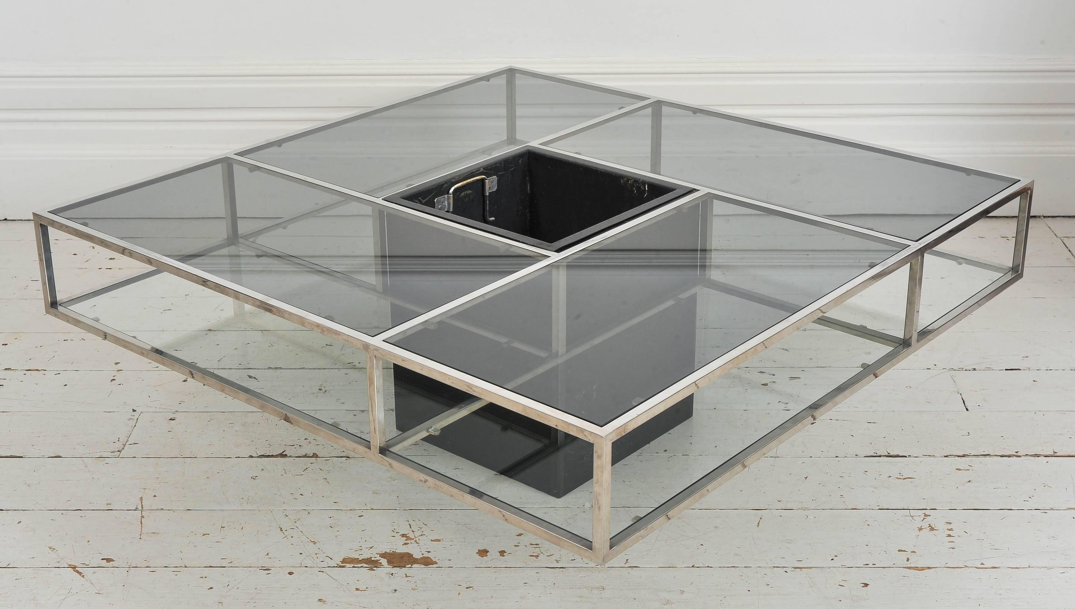 This table is a very clever and chic piece of 1970s design. The top has four rectangular pieces of smoked glass, and beneath, the glass is clear. The whole thing rests on a black metal pedestal leaving the glass sections appearing to float off the