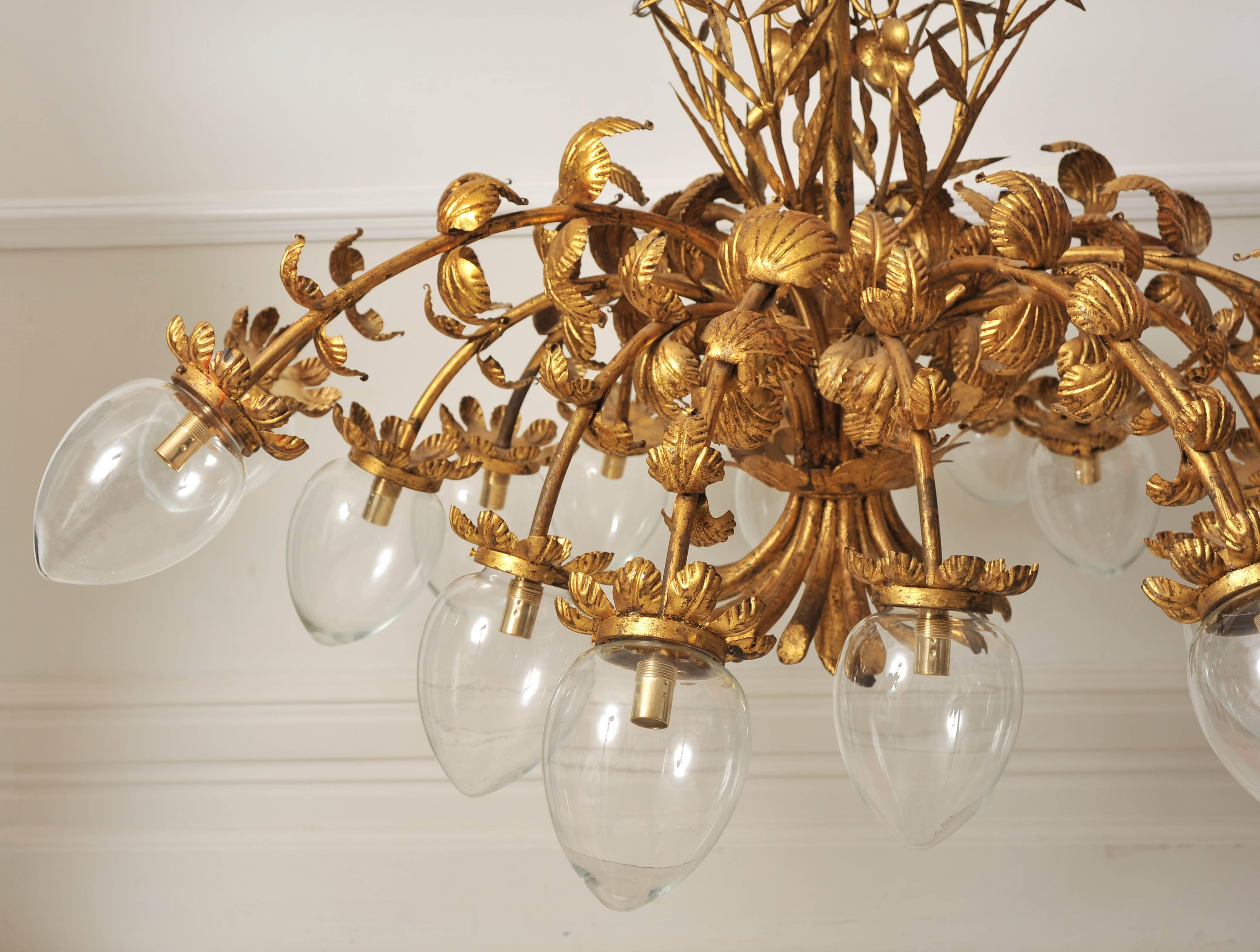 We have never seen another chandelier like this stunning example. It is incredibly decorative and striking. The chandelier is gold metal and is decorated with unusual leaves along each of it's 16 arms with stems at the base and grapes and vines at