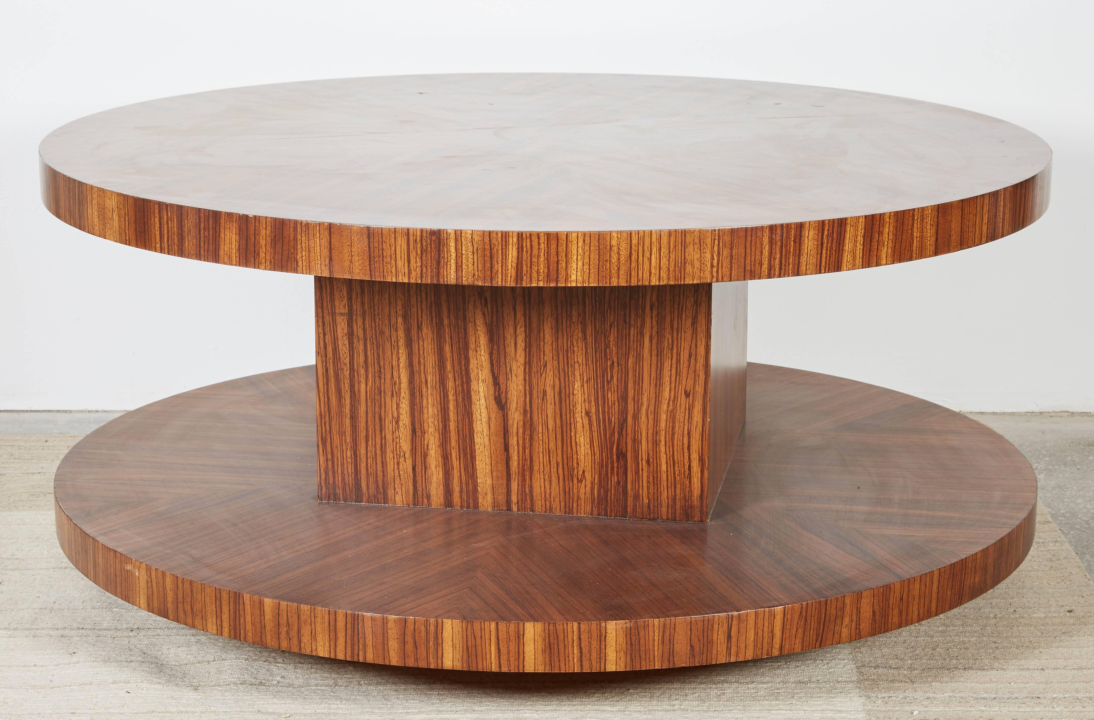 Modernist coffee table in zebrawood veneer with rotating top. The finish is rich and luminous and features a radial veneer layout. Minor scratches and wear consistent with the age and use of the piece.                            