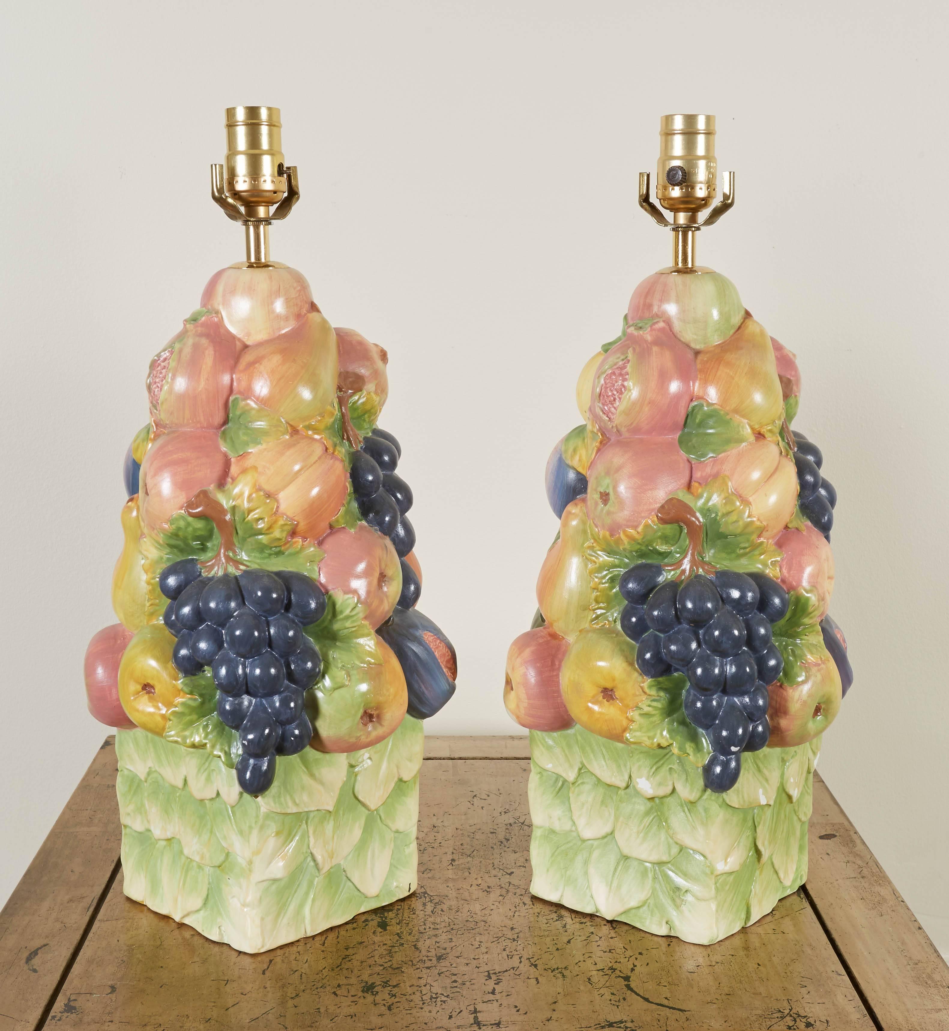 Each in the form of a cone-shaped arrangement of fruit including pomegranates, grape bunches, apples and pears on a foliate cube base.