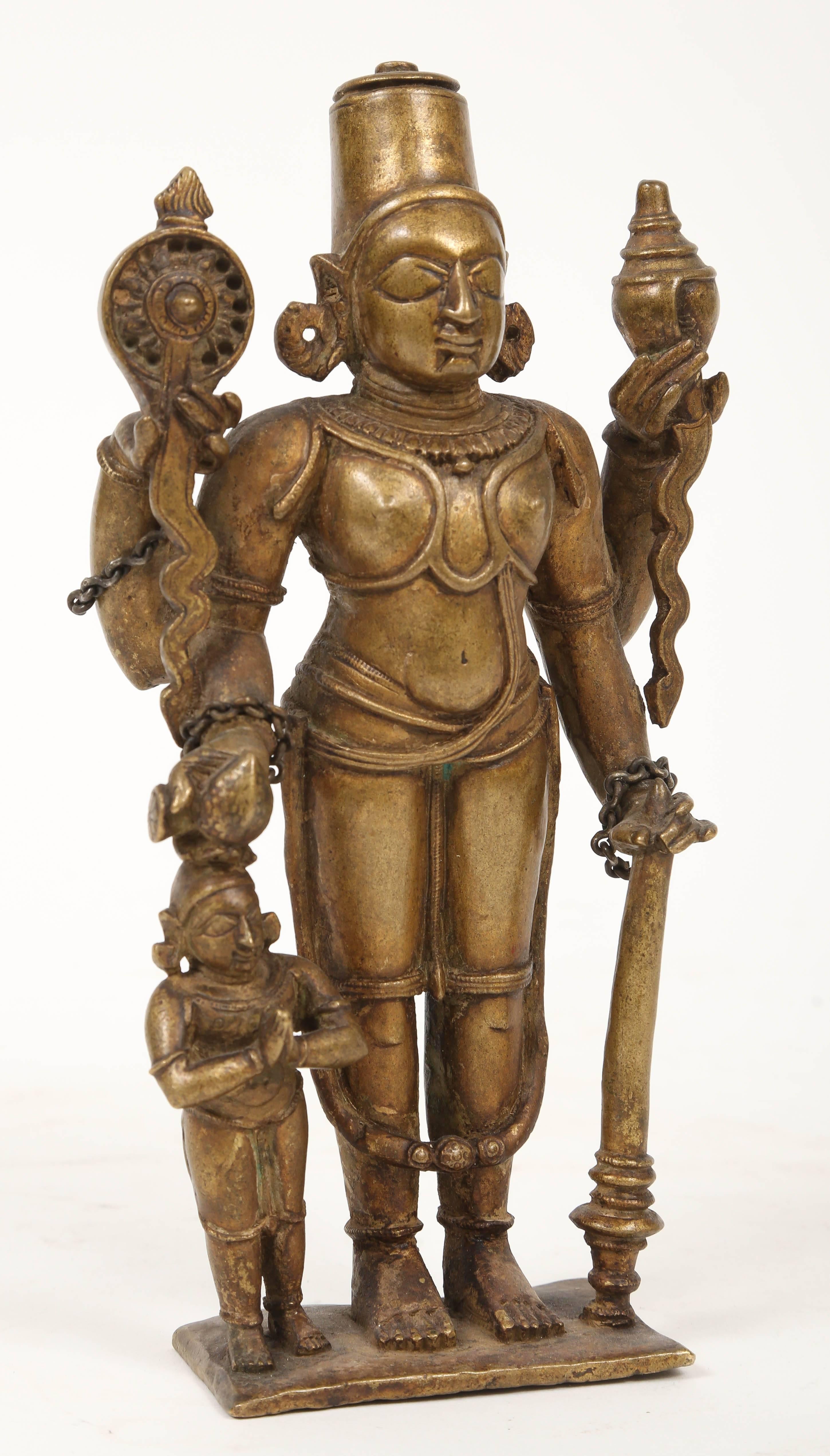 A four-armed depiction of the Lord Vishnu holding the discus and the conch in the rear hands of the upraised arms. The deity wears a high crown and has earrings and bracelets. A long heavy dhoti falls from the belt below the slender waist almost to