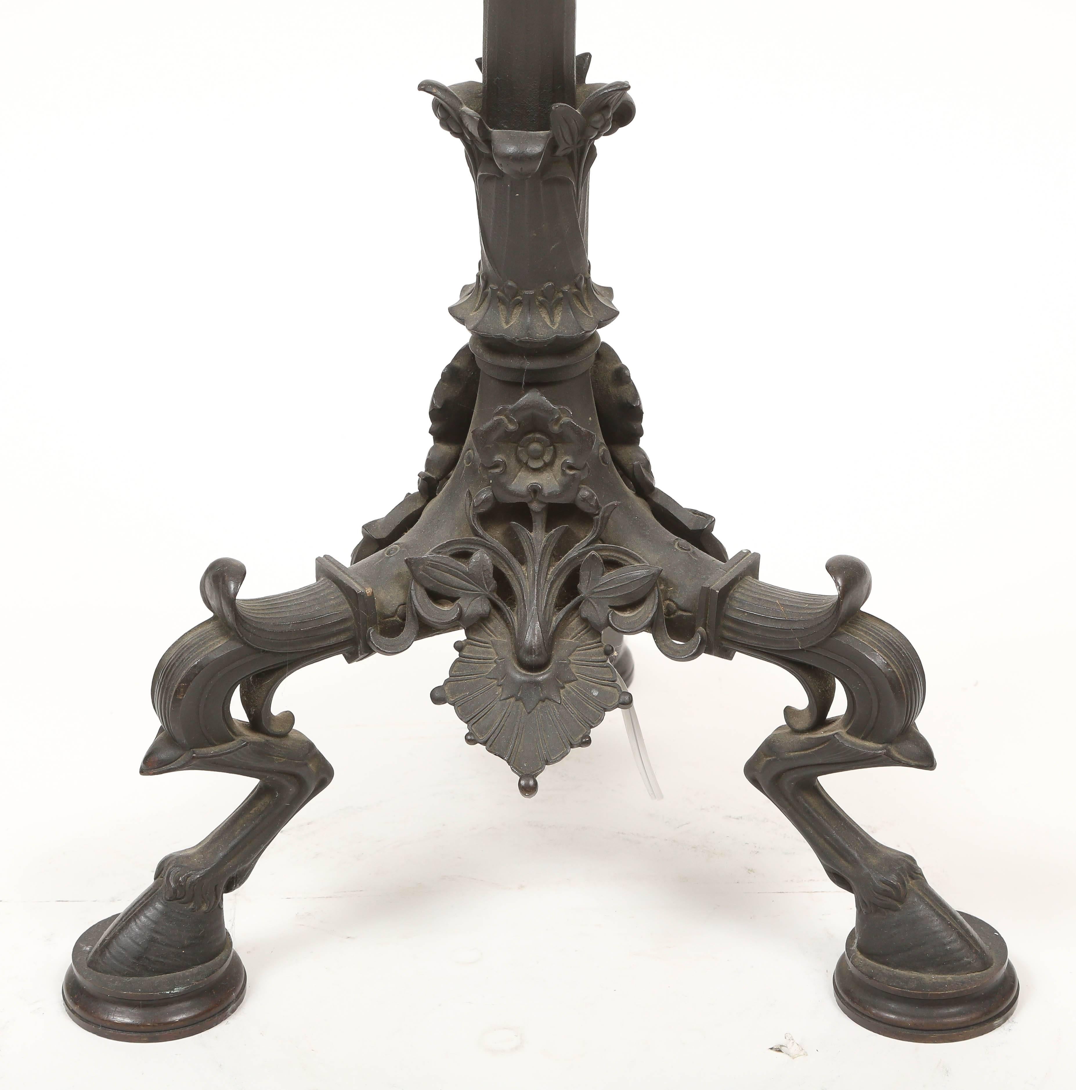 Rare lampadaire tripode de style pompéien attribué à la fonderie Caldwell & Company. Finition bronze patiné vert-de-gris. Électrifié avec deux prises de courant.