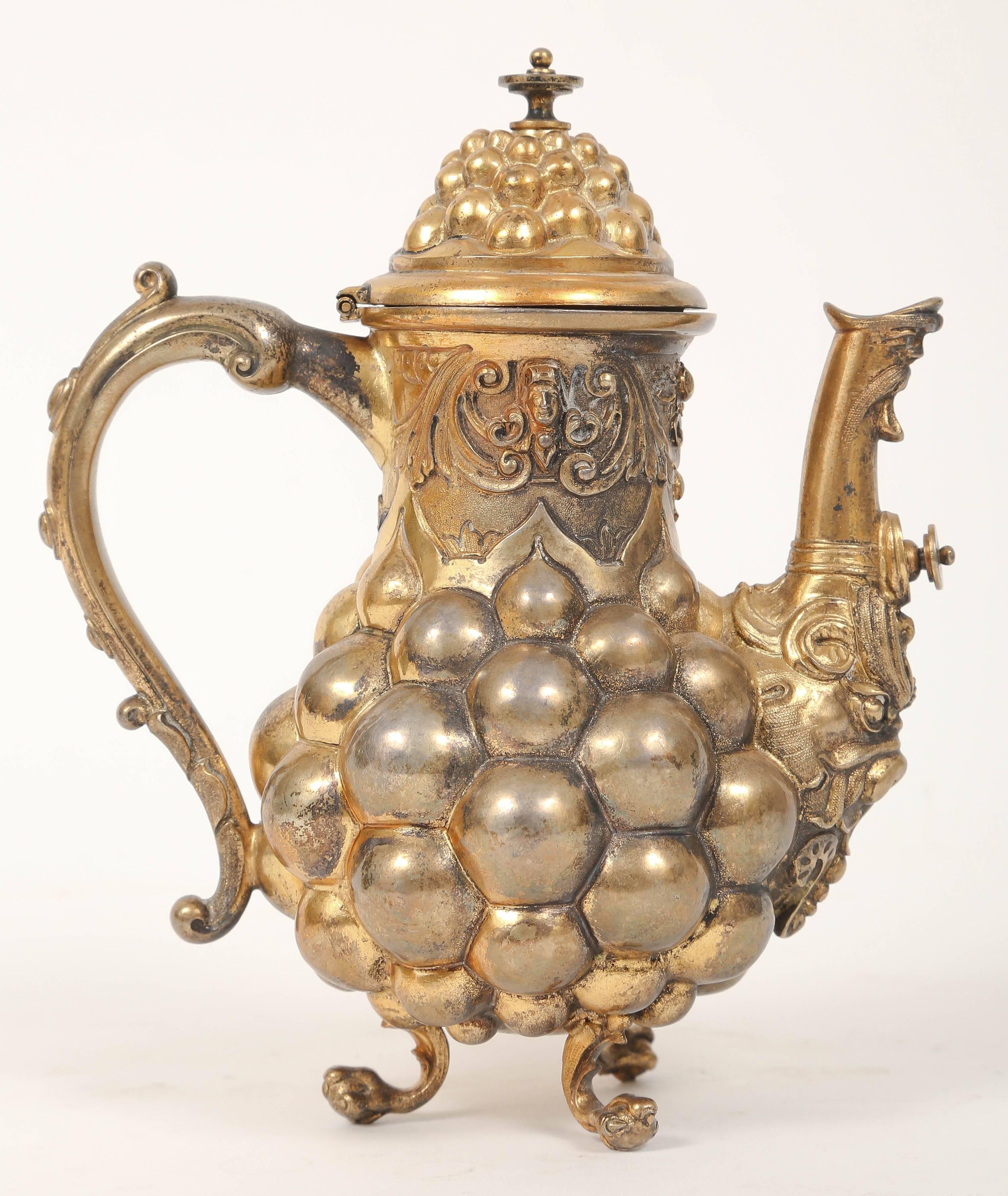 A rare and true rococo fantasy coffee pot. Fire-gilded vermeil, gilt silver, repousse with mannerist detailing including lobes, garlands, grotesque masques, scrolls, and rocaille. Magnification reveals elaborate punch work and tooling. The pot rests