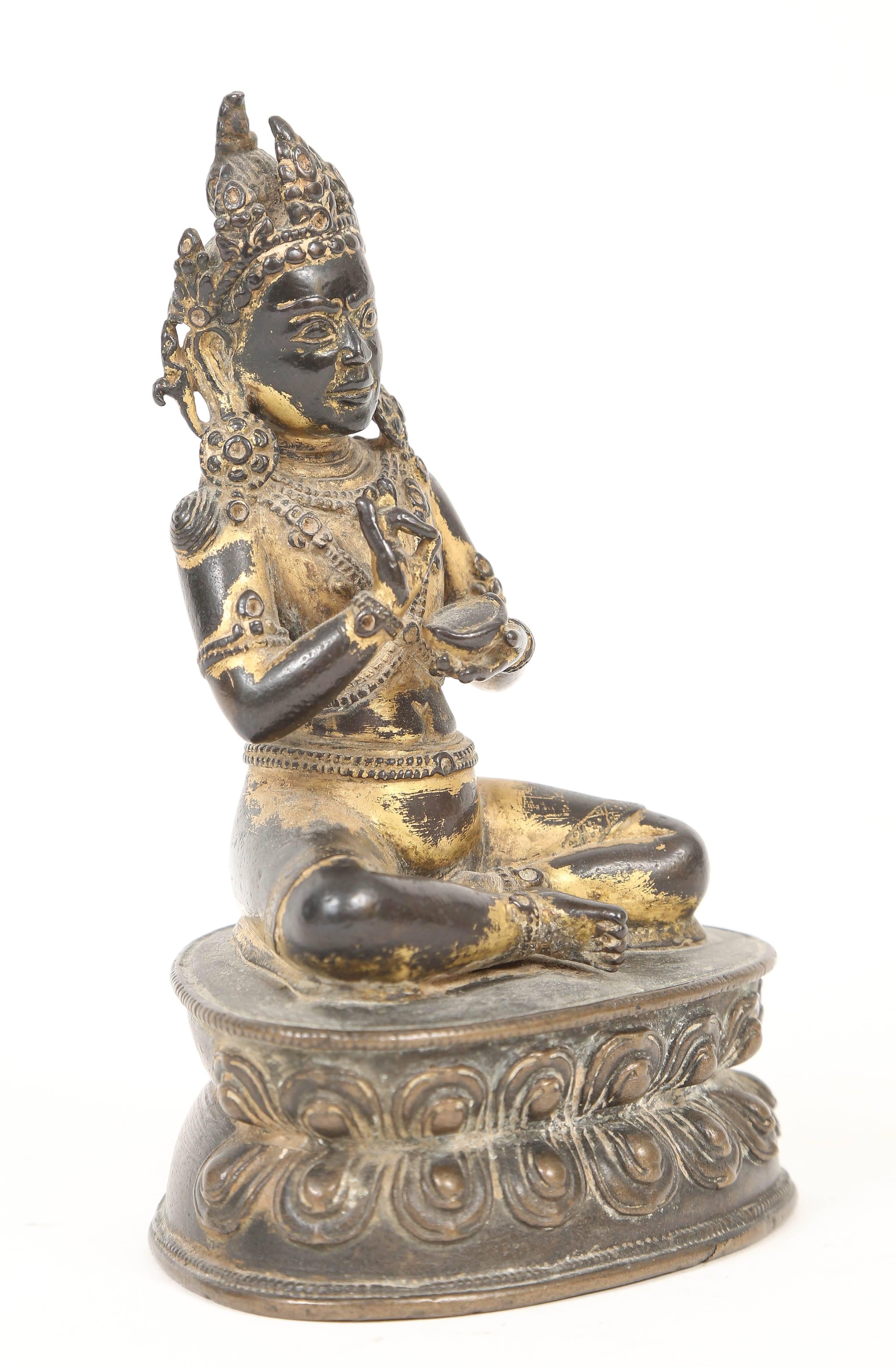 A gilt bronze figure of the Buddha Amitayus, Tibet, 18th century, cast in the Pala revival style, particularly popular in 18th century Tibeto-Chinese statuary, seated on a waisted lotus pedestal, cradling the amrita vase above his lap, adorned with