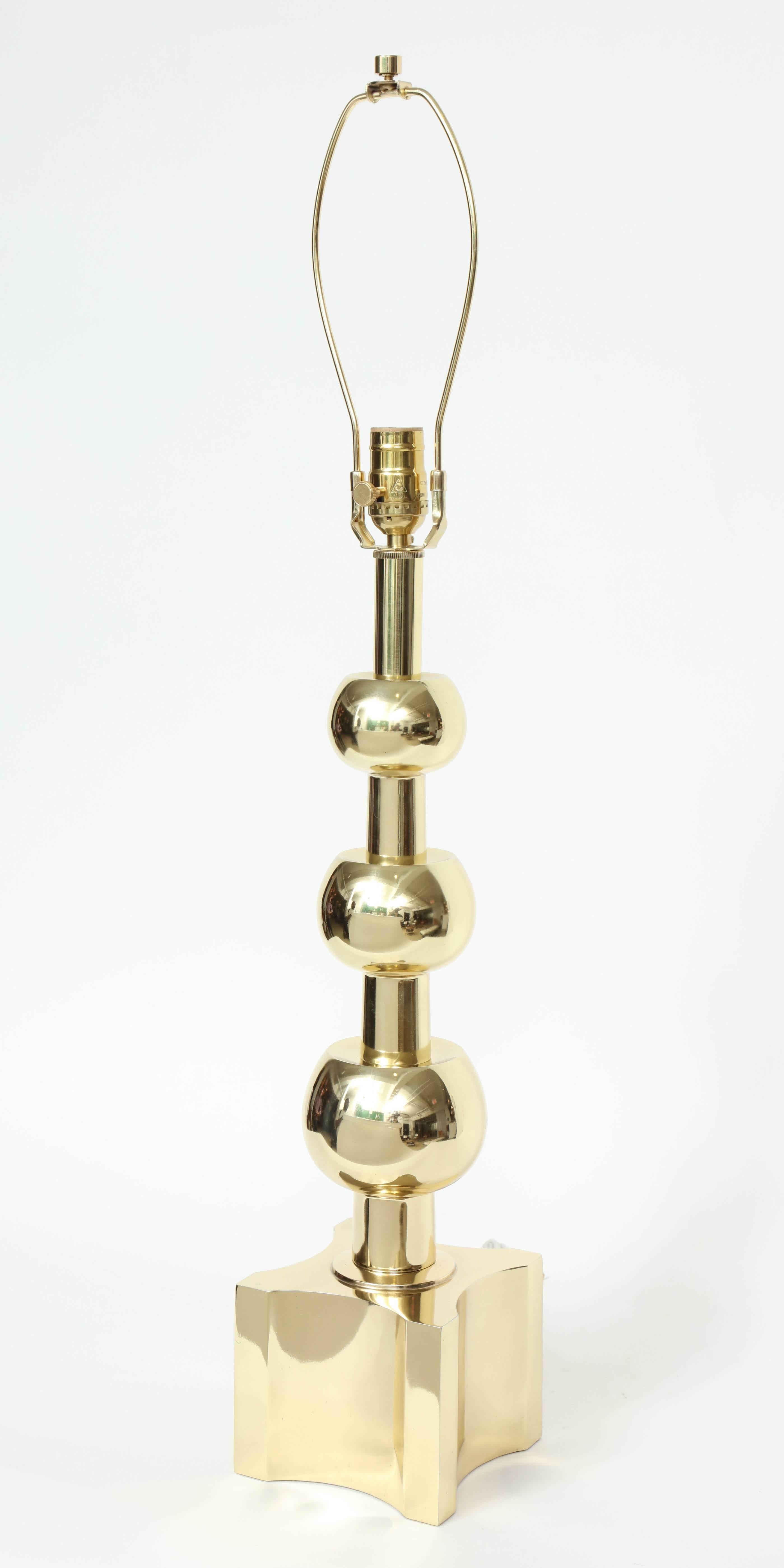Ein Paar von Tommi Parzinger beeinflusste Mid-Century Classic Lampen aus poliertem Messing mit drei gestapelten, abgestuften Kugeln auf einem quadratischen Sockel mit konkavem Zentrum. Für die Verwendung in den USA umverdrahtet.