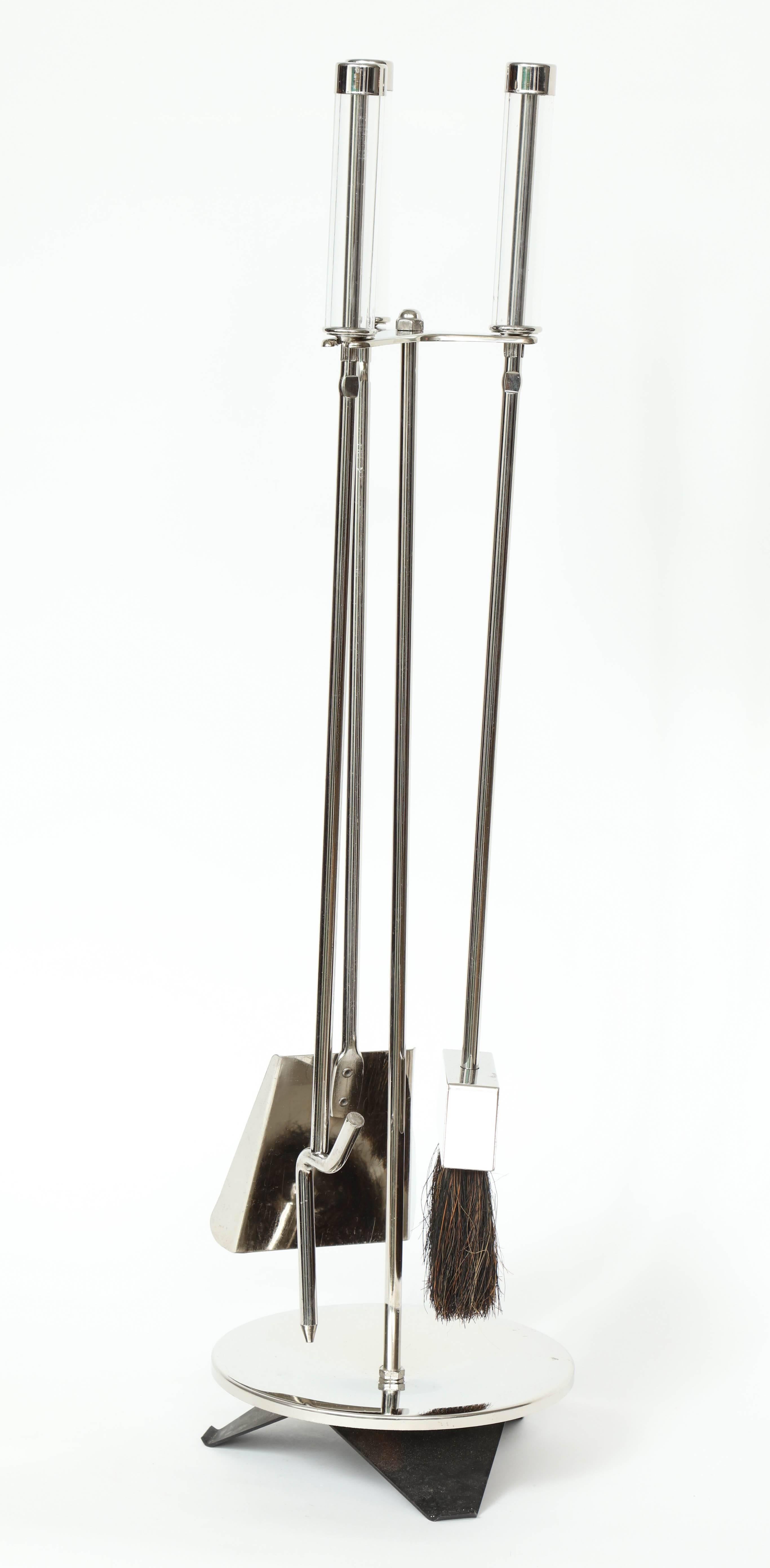 Set of three streamlined polished nickel fire tools with Lucite handles suspended on a nickel frame with black enamel flared base.