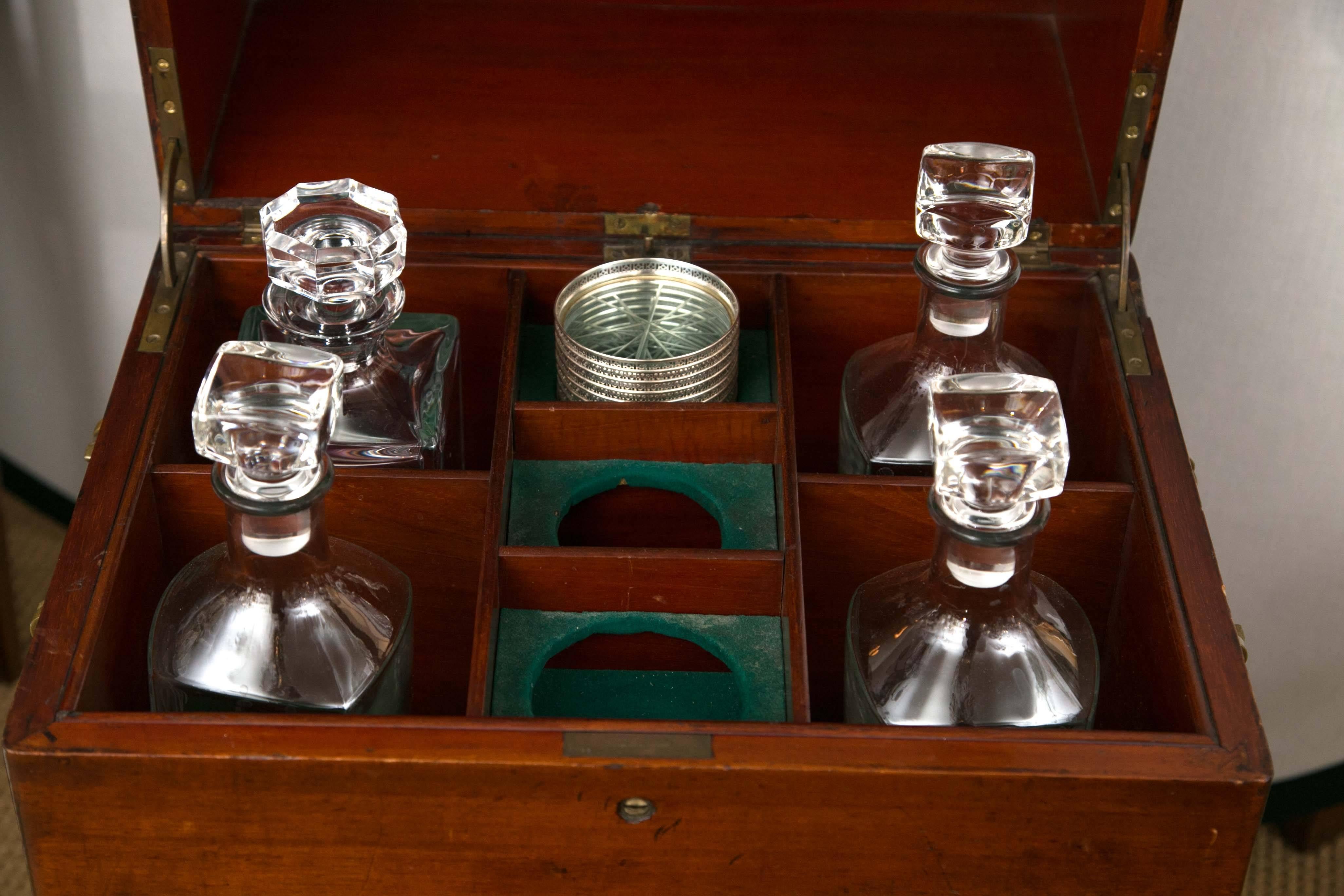 A stunning solid mahogany rolling dry bar. The lid opens to reveal compartments for decanters and coasters. The drawer below includes glasses. The third-drawer is a humidor by C.N. Swift of New York. 
The bottom two drawers are made for a variety