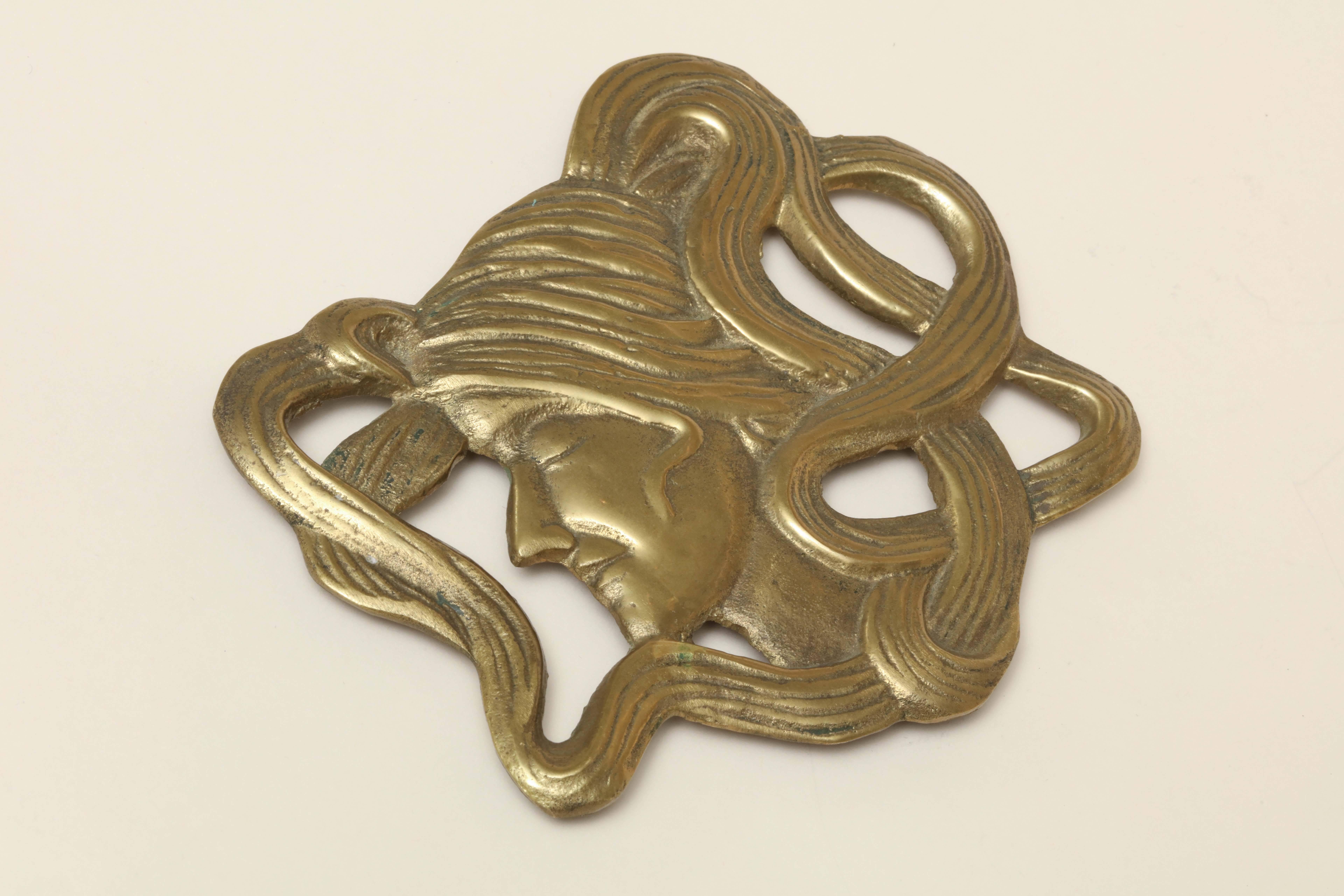 Vintage Art Deco brass trivet with flowing hair lady.