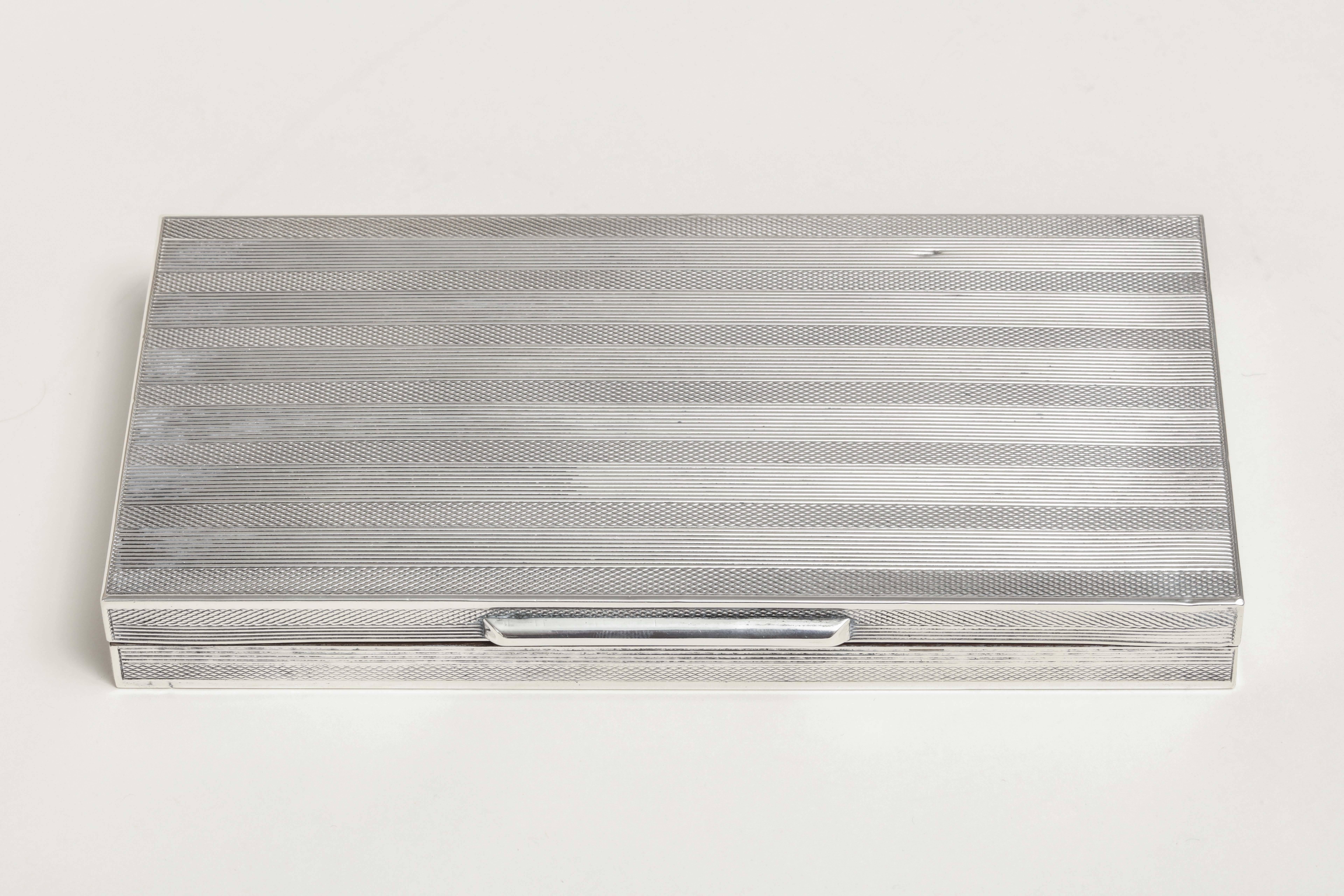 Engine-turned rectangular silver cigarette box lined with wood.
Impressed 800/ unintelligible maker’s mark.

Measures: 8.25” wide; 4.25” long; 1” high. 
9.20 ozs. gross.

(Price shown is reduced price, no further trade discount) 