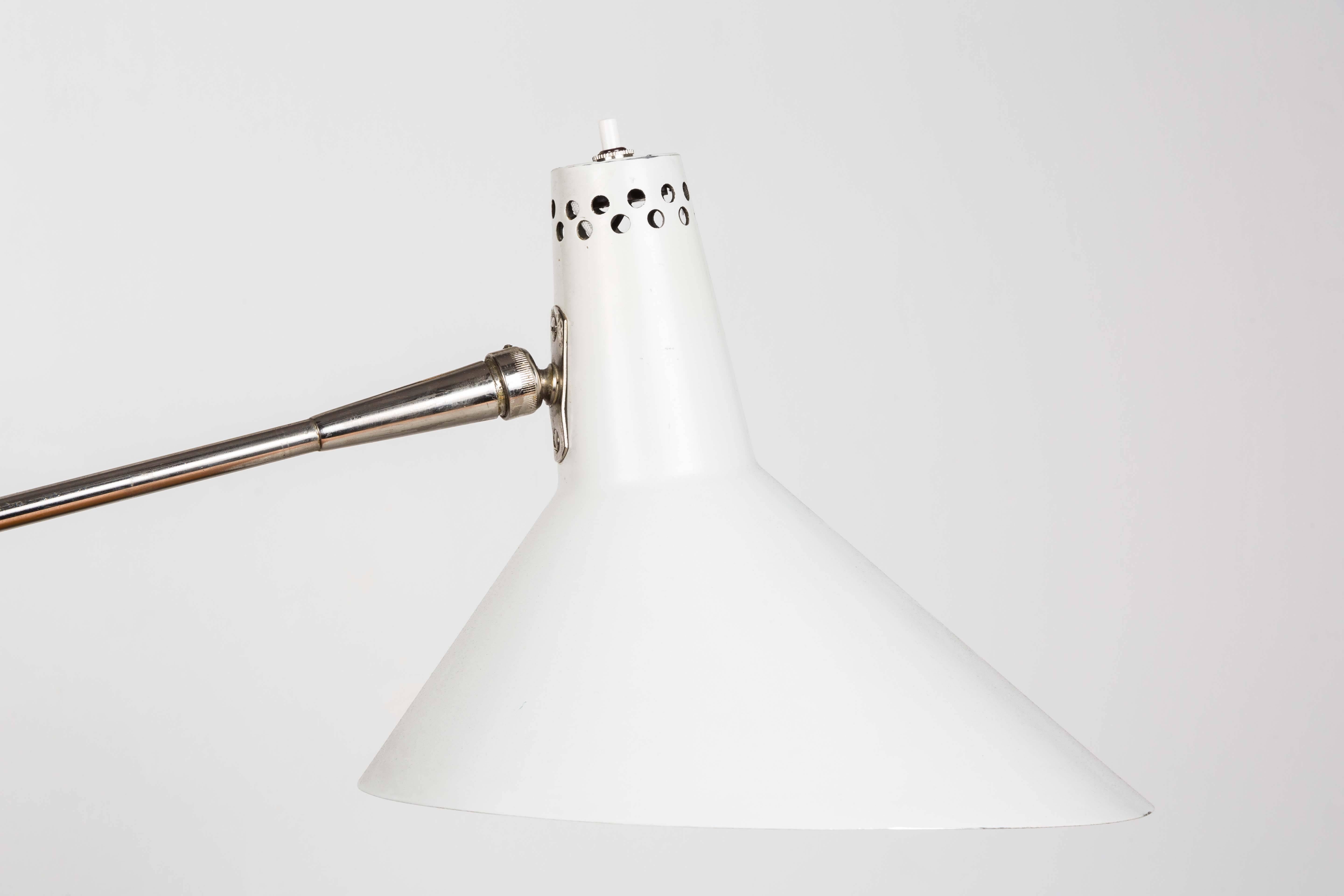 1960s articulating task lamp attributed to Arteluce. An quintessentially 1960s Italian architecturally minimalist design executed in chrome and white enameled metal. Highly adjustable, the Dual-jointed articulating arms extend up to a maximum of 38