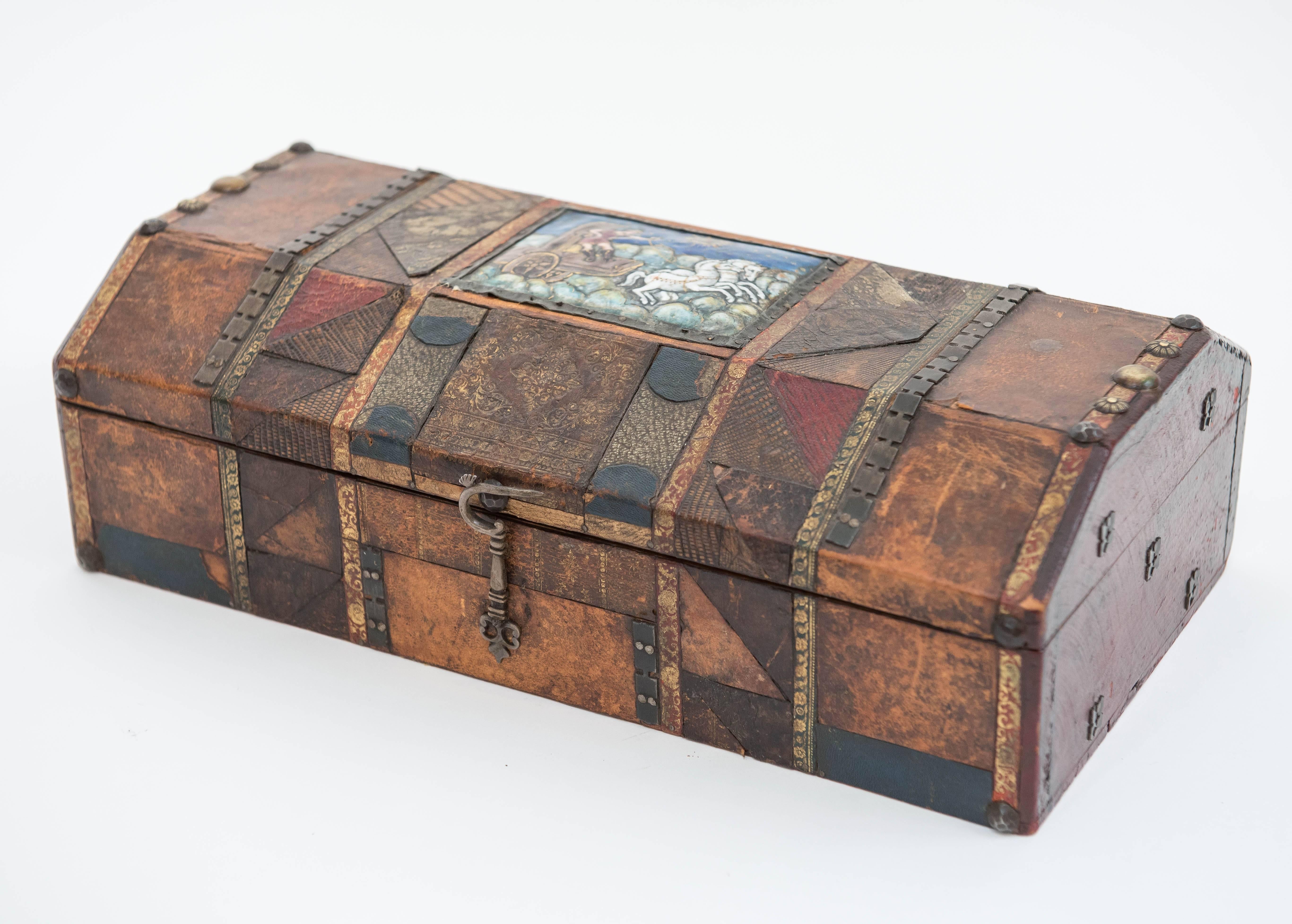 A most unique patchwork leather covered wood box with highly decorative
plaque, nailhead studs and other assorted ornamentation. The inside is 
beautifully lined with antique paper.