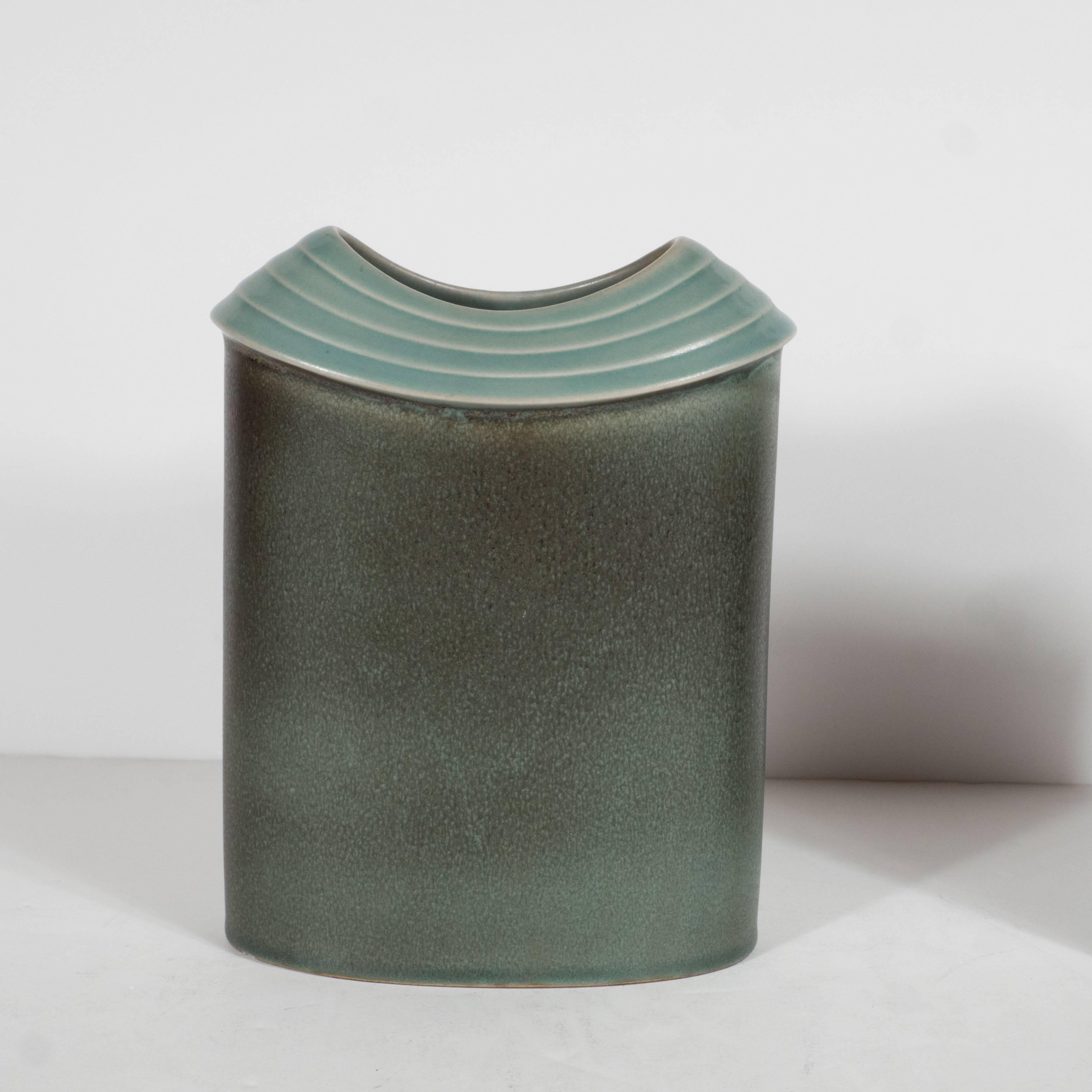 This sophisticated pair of vases were realized by the esteemed maker Rosenthal in Germany circa 1960. Ovoid in shape, they feature an incised four-tier outer edge. The vases are hues of a celadon glazed body with a sea green outer edge. The vases