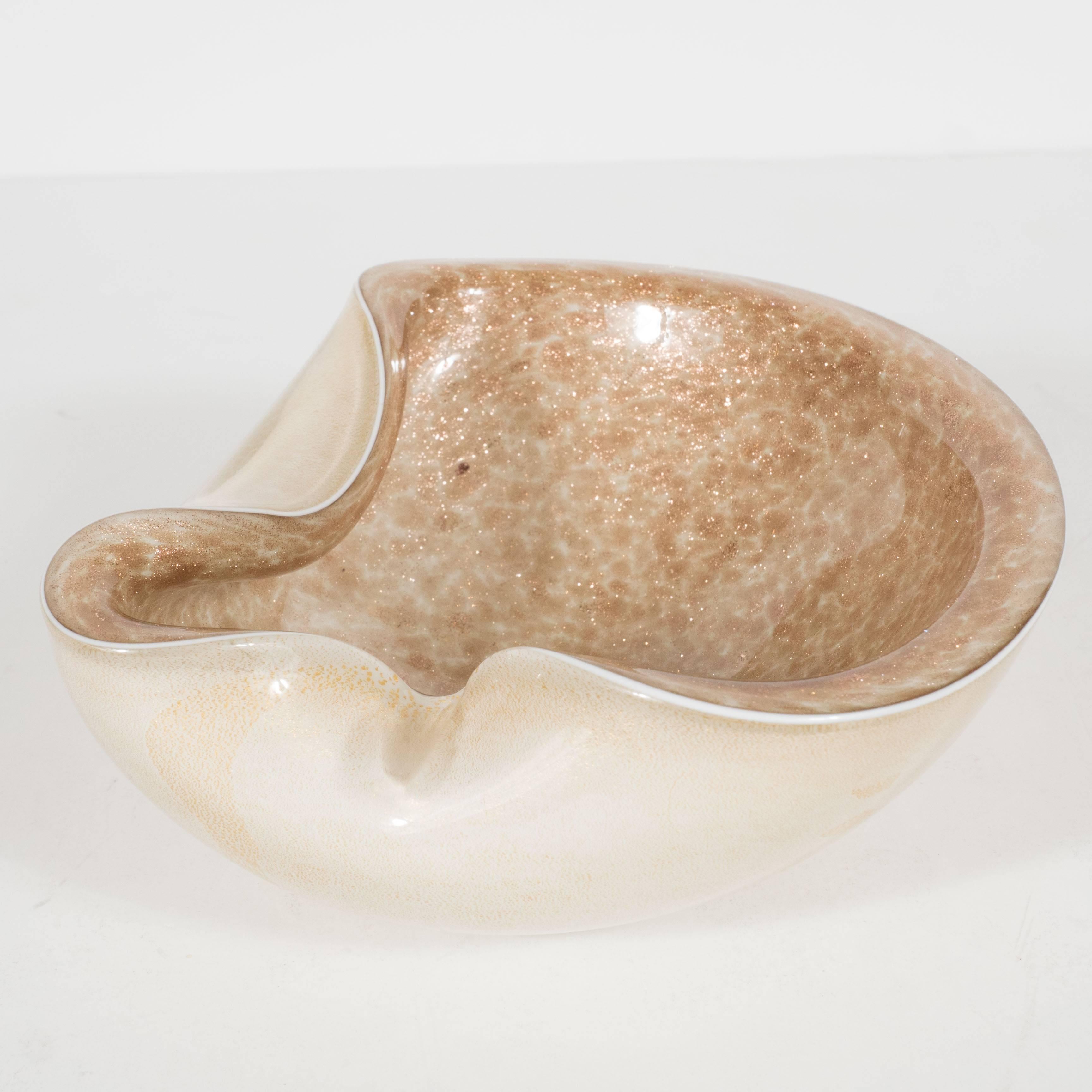 A Mid-Century Modernist bowl, objet or ashtray. This handblown piece of Murano glasswork features a clean, 24-karat yellow metallic gold exterior and speckled interior warm-hued interior. It is in excellent condition.
Made in Italy, circa