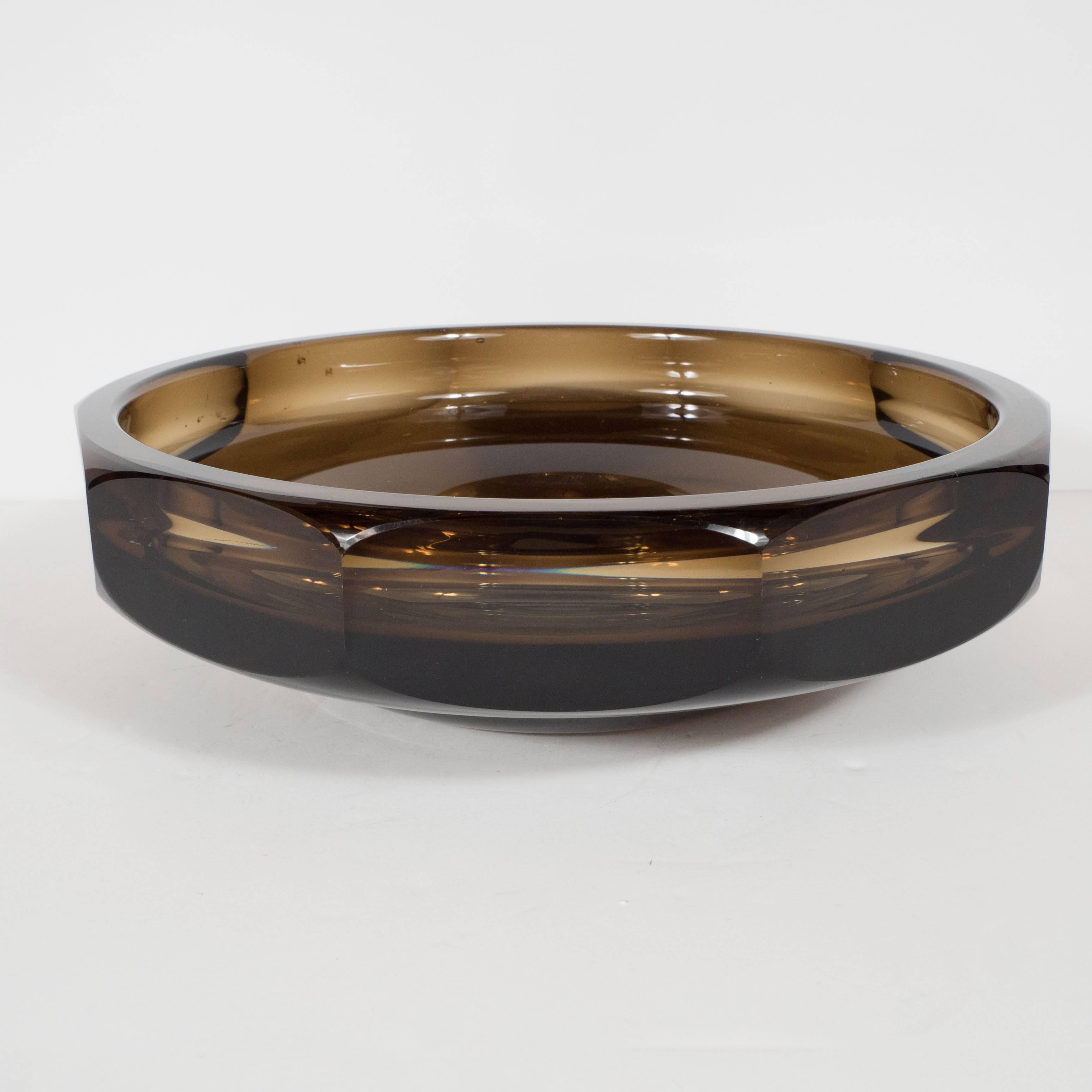 A stunning Mid-Century Modernist glass bowl in dark smoked topaz by Daum, Nancy. A circular, low form with curved stepped base supports a faceted bowl with beveled corners. This pieces features a smooth, round interior which juxtaposes beautifully