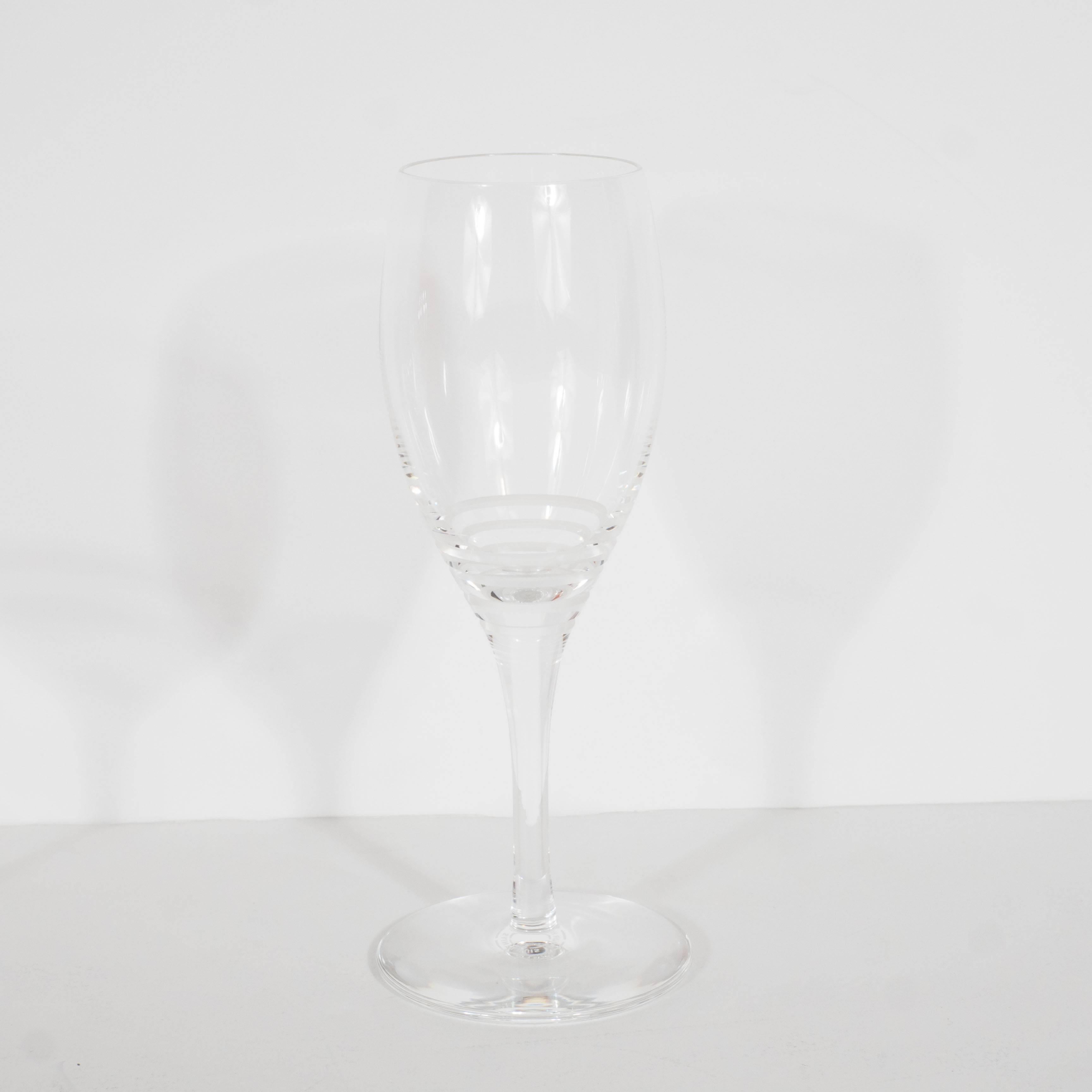 A suite of 12 of each red, white and champagne crystal glasses by Saint-Louis for Hermes, totaling 36 pieces. A Minimalist design features standard proportioned stem-to-bowl. Equidistant bands of etched carvings travel across the perimeter of the