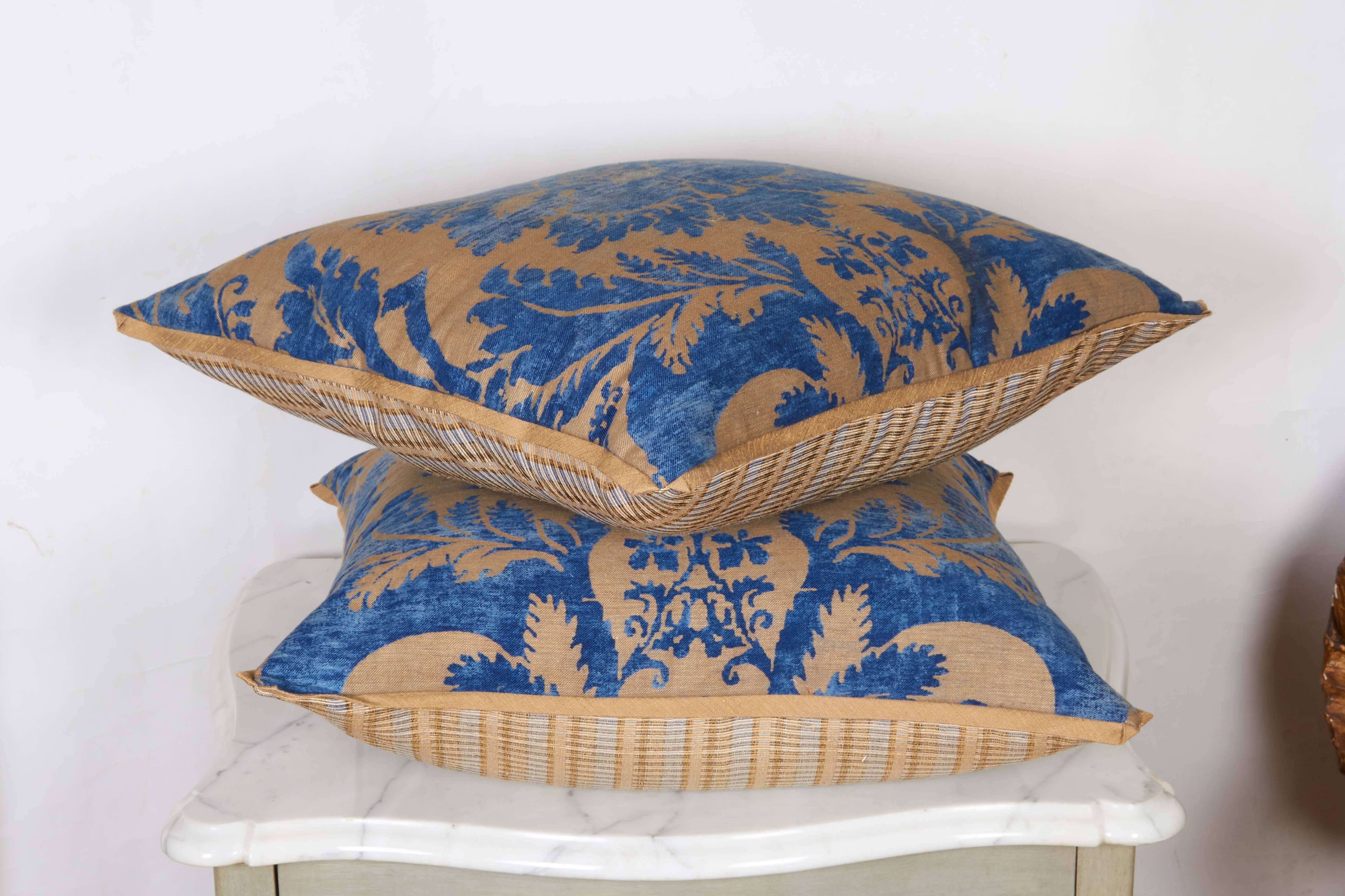 A pair of Fortuny fabric cushions in the Glicine pattern, indigo and sand color way with silk blend backing material and silk bias edging, the pattern, a 17th century Italian design with wisteria motif. Newly made using vintage Fortuny fabric, circa