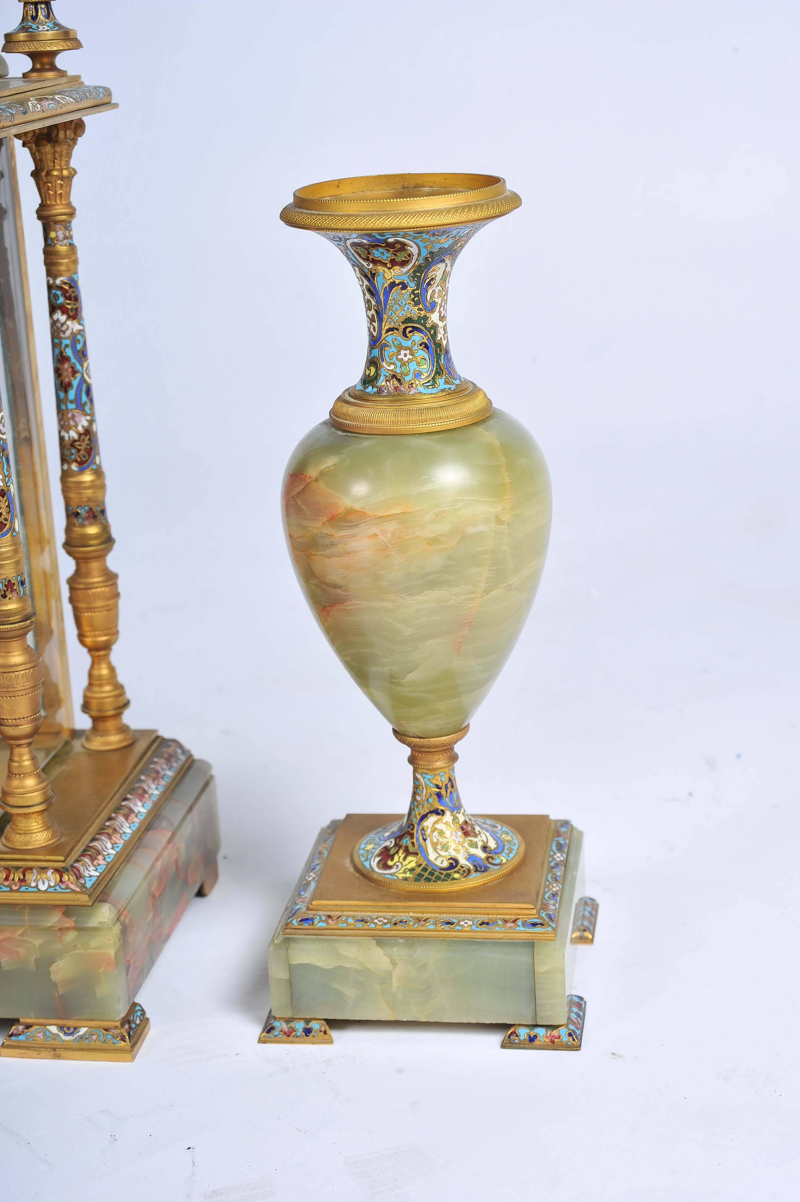 An impressive 19th French 19th century onyx, gilded ormolu and Champleve enamel clock garniture.