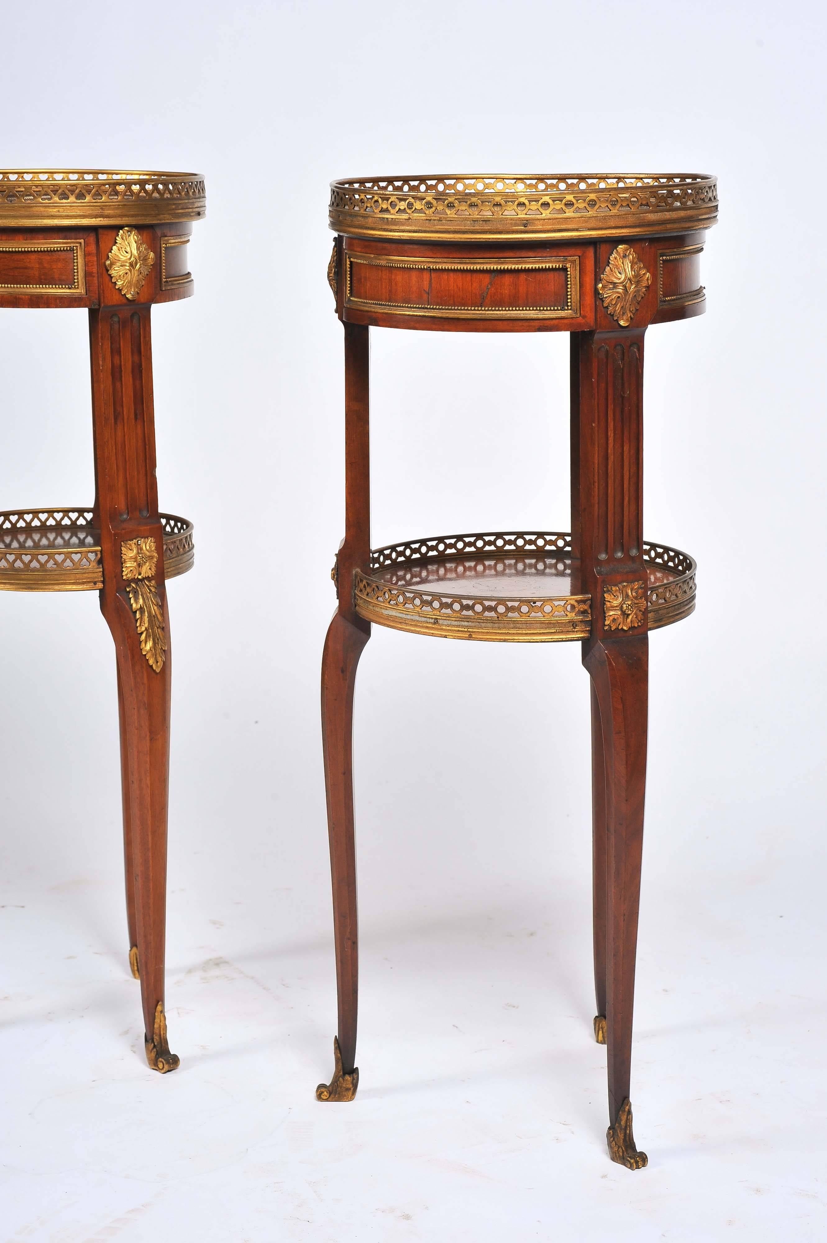 A good quality near pair of French 19th century mahogany empire influenced side tables. Each having a brass gallery to the top, quartered veneer, raised on three fluted tapering legs with an under-tier and classical ormolu mounts.