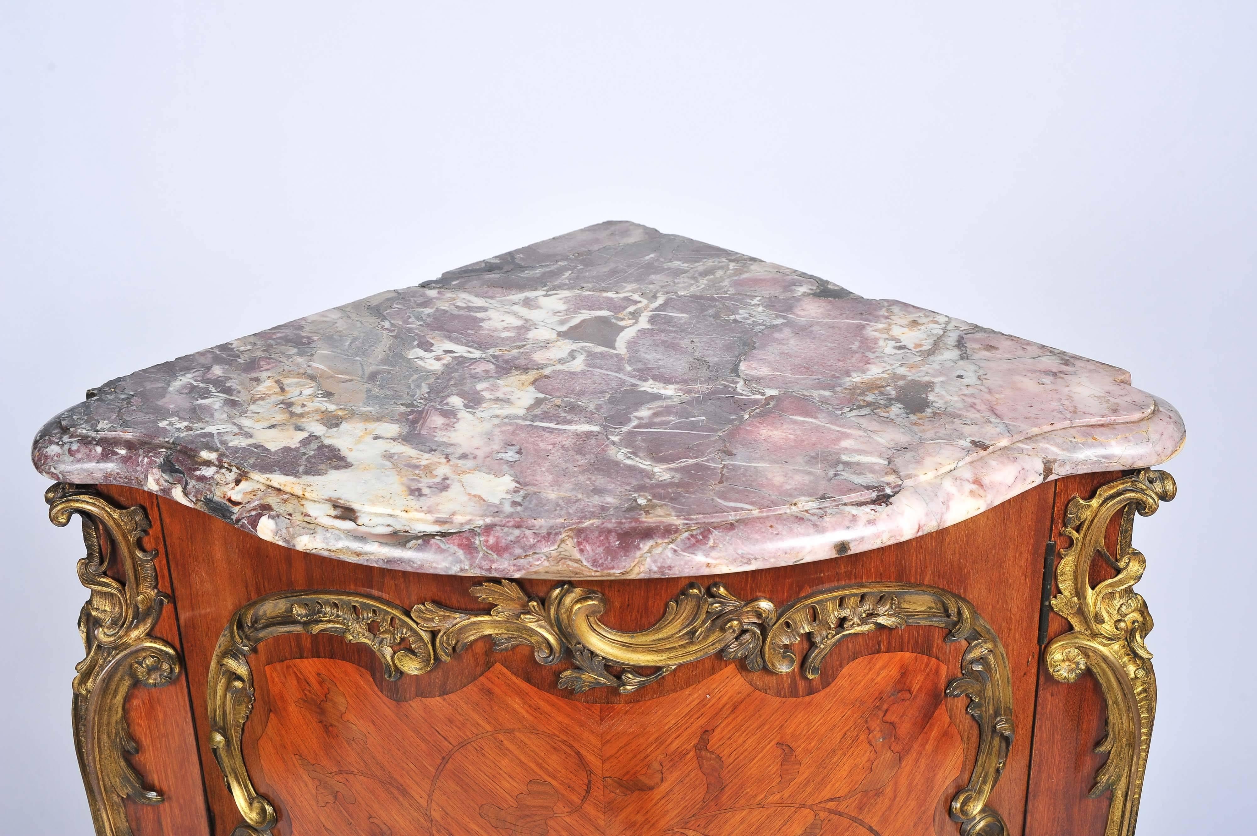 A good quality French, 19th century, kingwood marquetry inlaid corner cabinet, having its original Breccia marble top, the inlaid decoration of flowers and gilded ormolu mounts. The bombe fronted door opening to reveal a shelf within and raised on